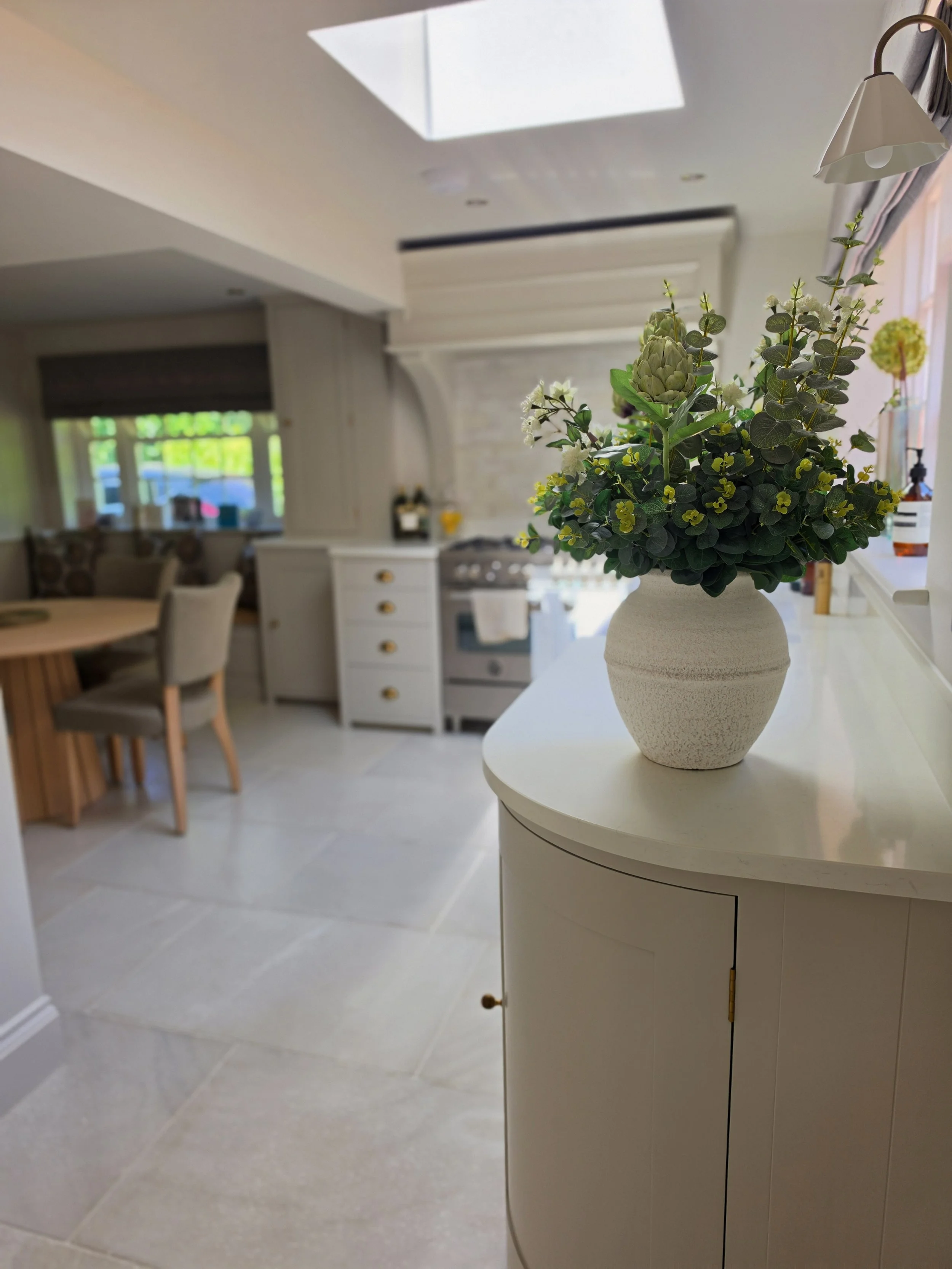 Kitchen-diner in Winkfield with painted units, stone floor and a rooflight over the work area