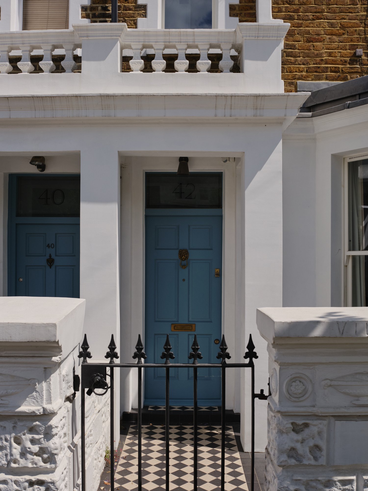 Blue front door with black iron railings at the house entrance at a house renovation on Priory Road, Chiswick, W4 by Robin Services.