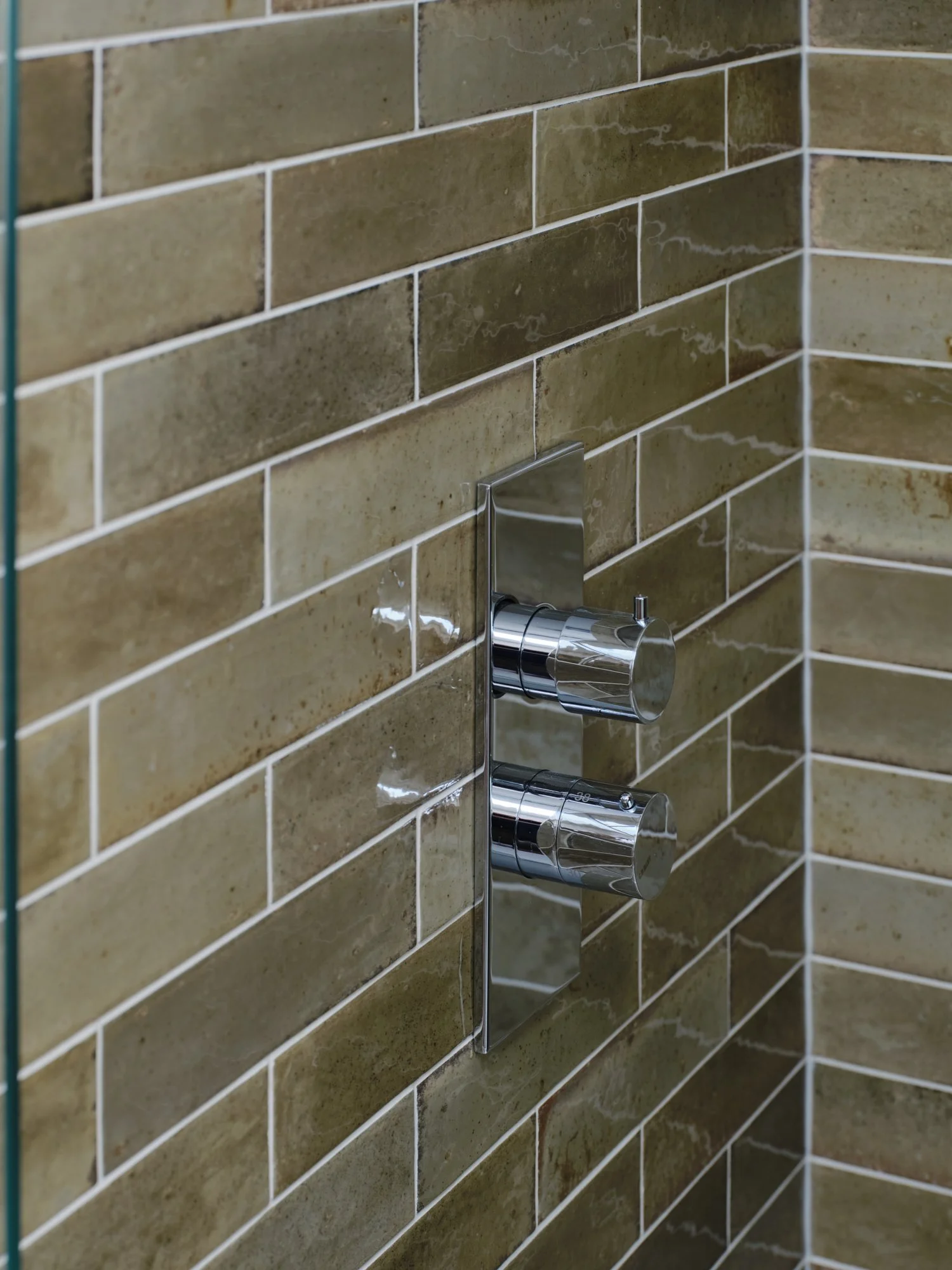 Bathroom wall with olive glazed tiles and chrome shower valve at a house renovation on Priory Road, Chiswick, W4 by Robin Services.