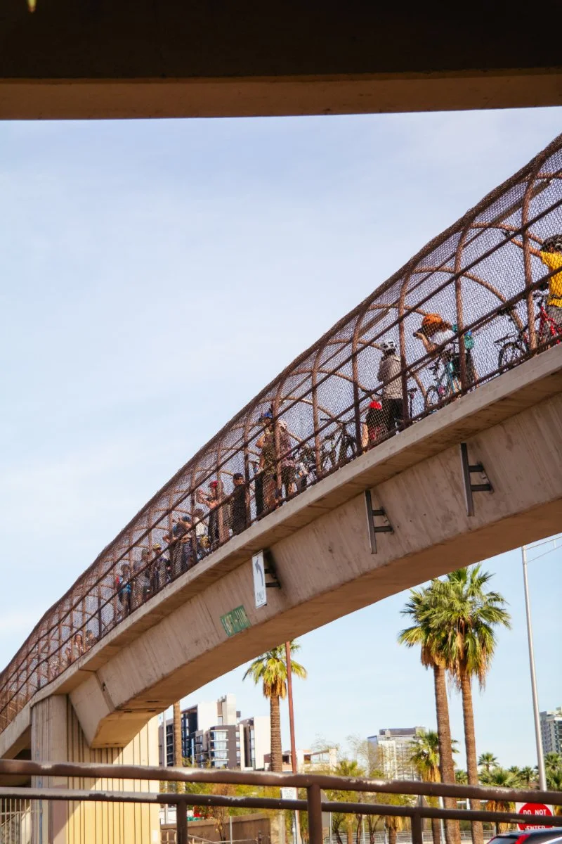cyclists on a pedestrian bridge in the desert