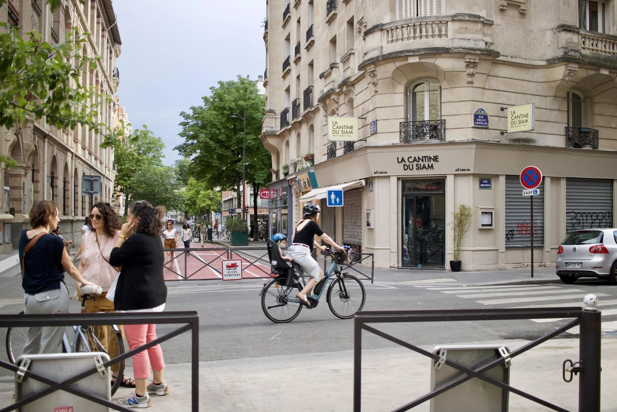 Women talking and biking on a street in Paris that is closed down to cars