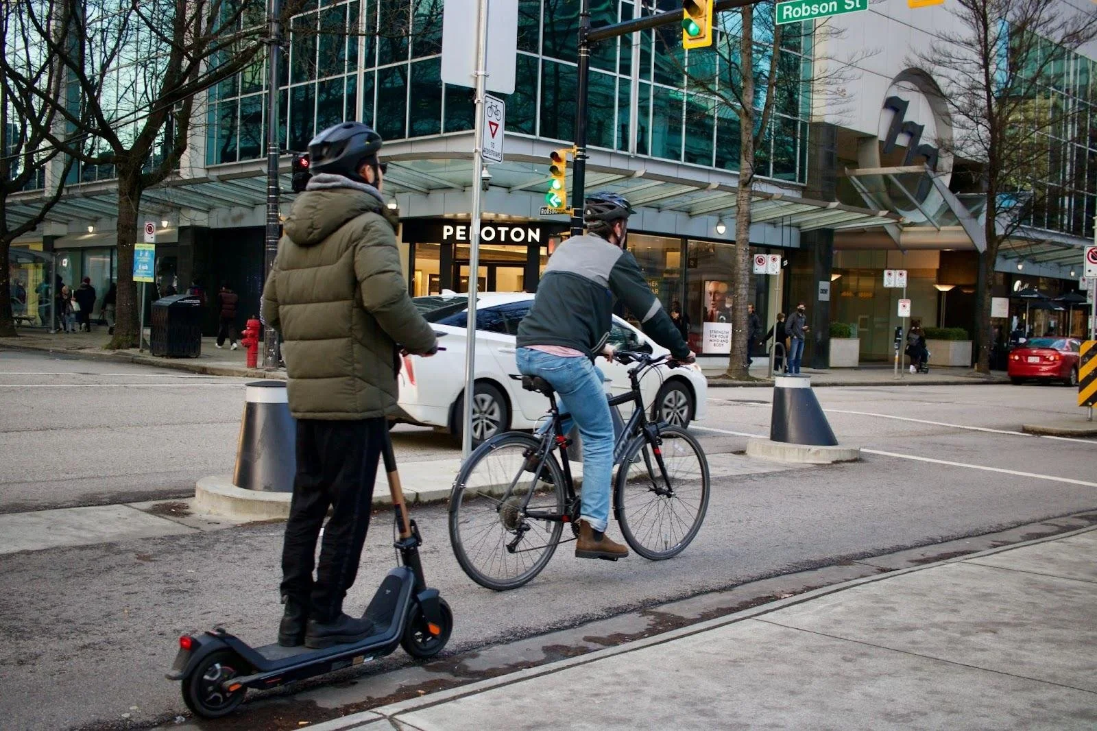 Two men are using active transportation on a city street