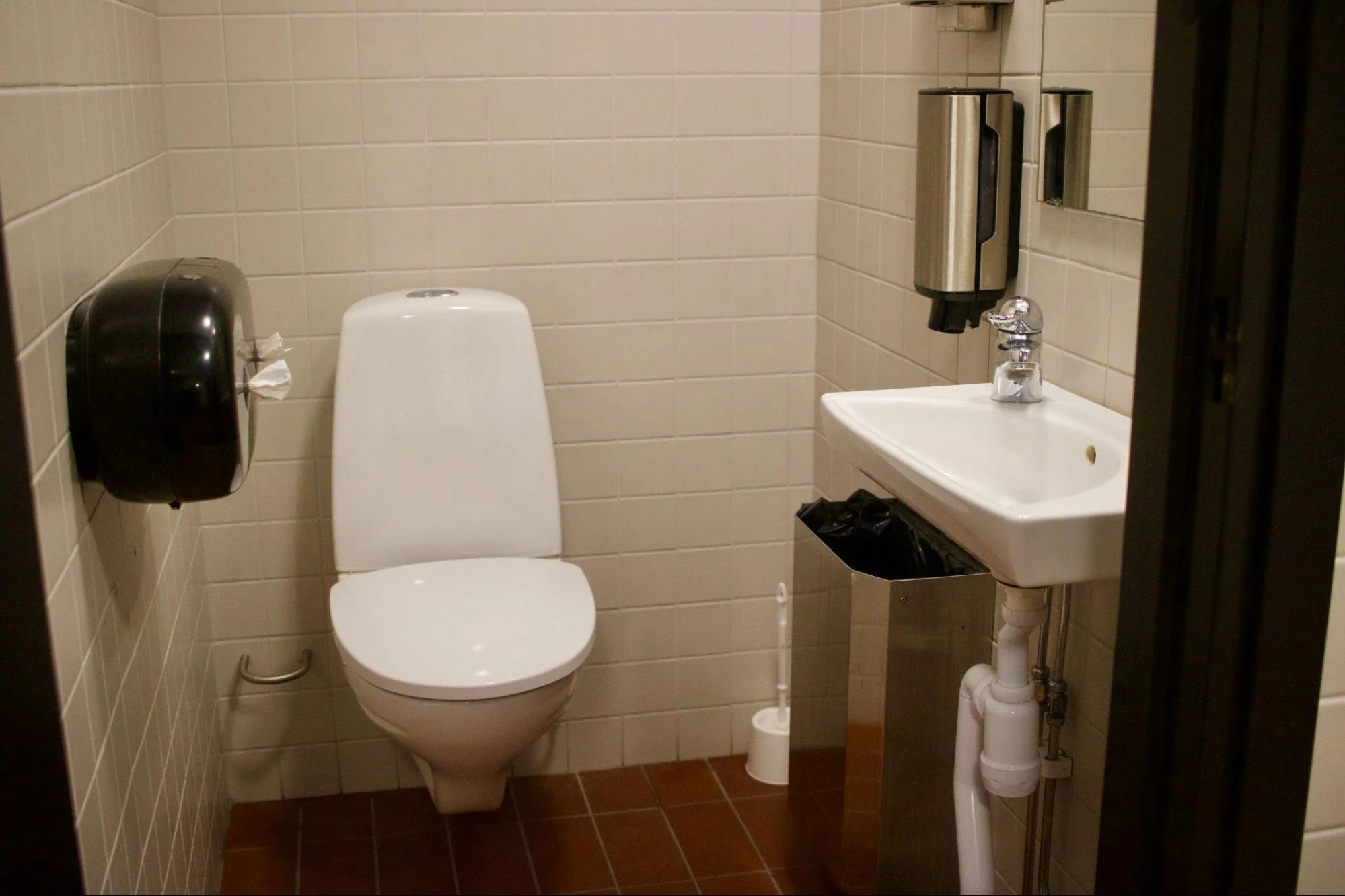 One of many bathroom stalls that includes a closed door and private sink in Stockholm, Sweden (photo by: Nicole Roach)