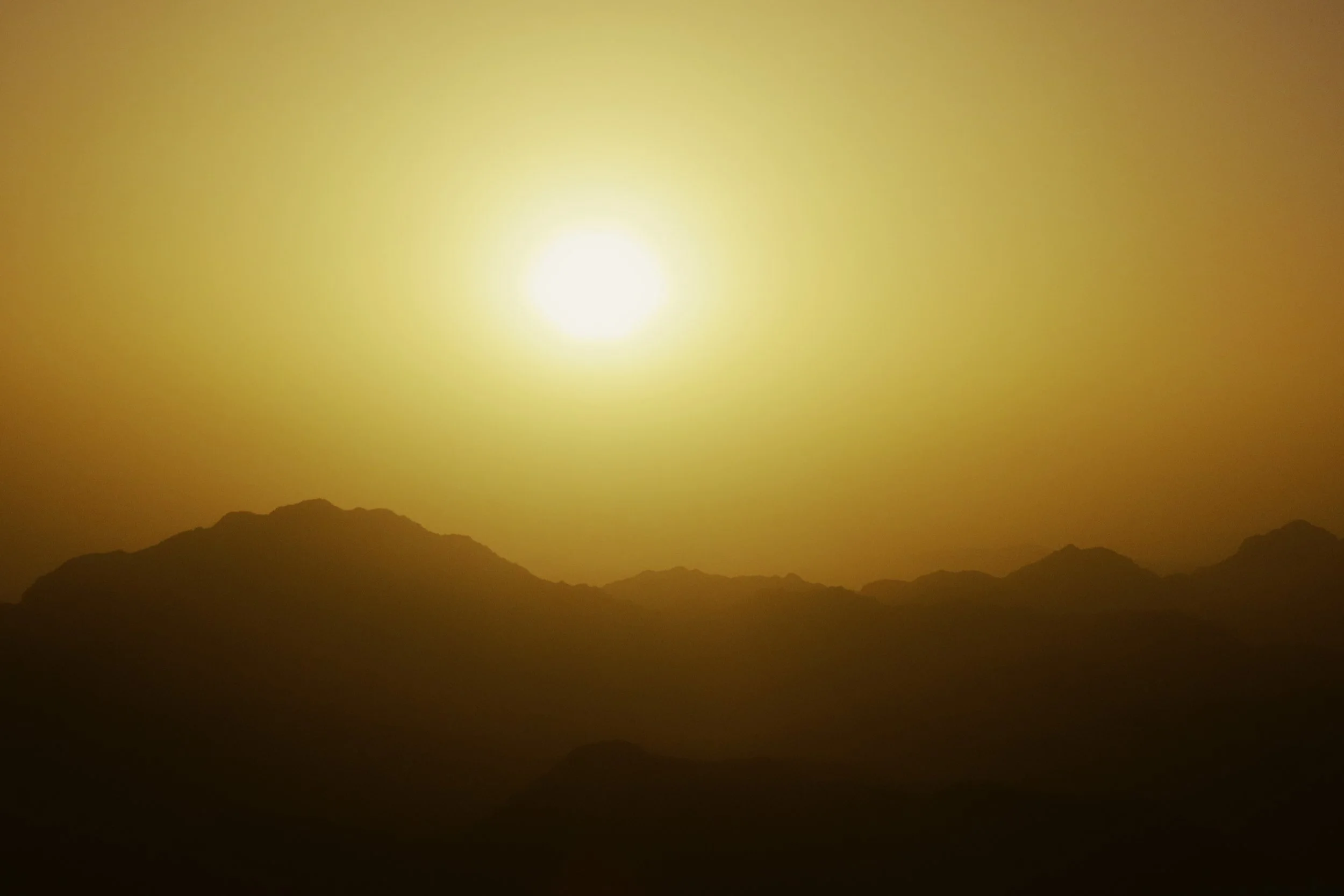 Sole che splende sopra montagne silhouette.