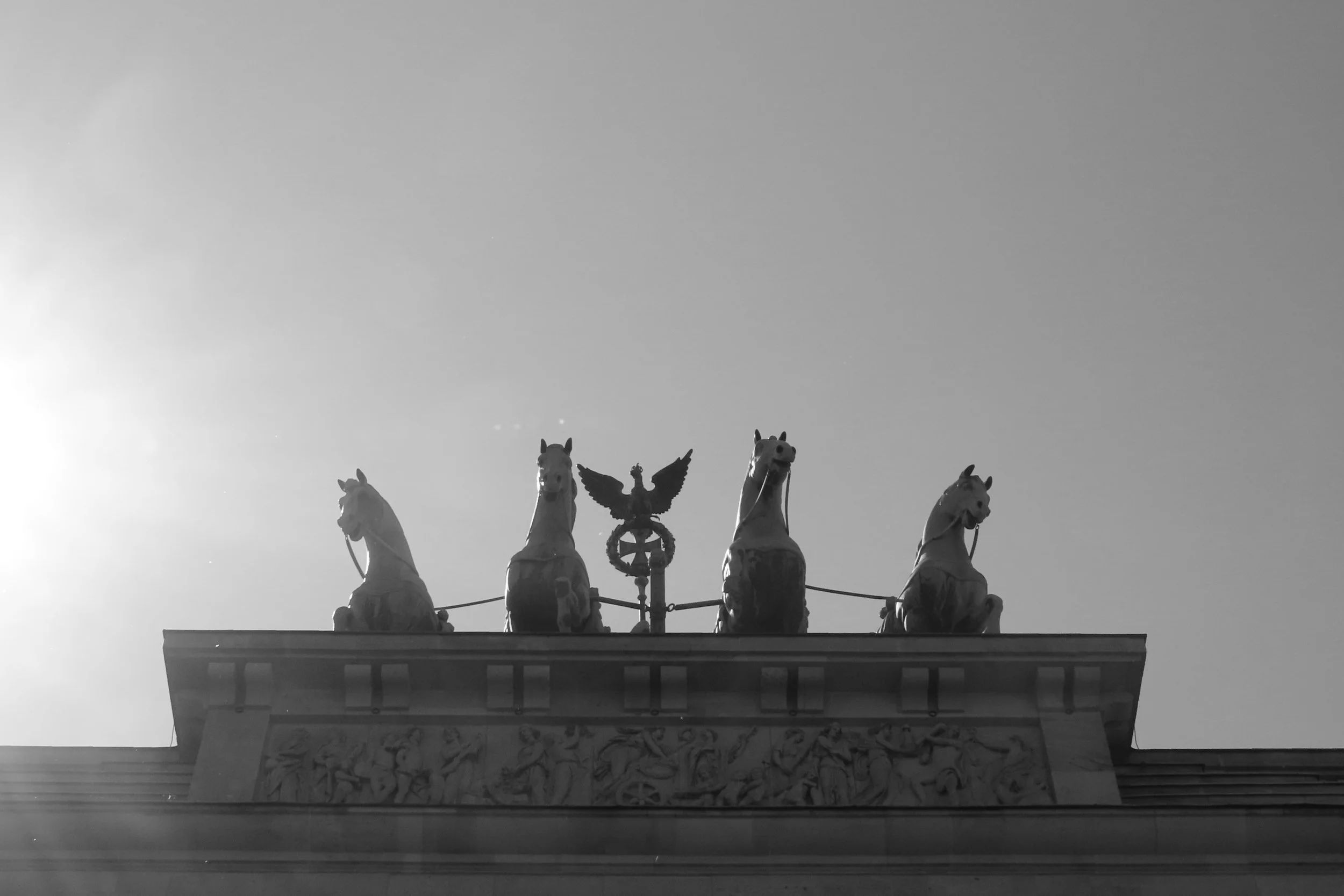 Statua con quattro cavalli e un'aquila al centro, situata sulla sommità di un edificio.