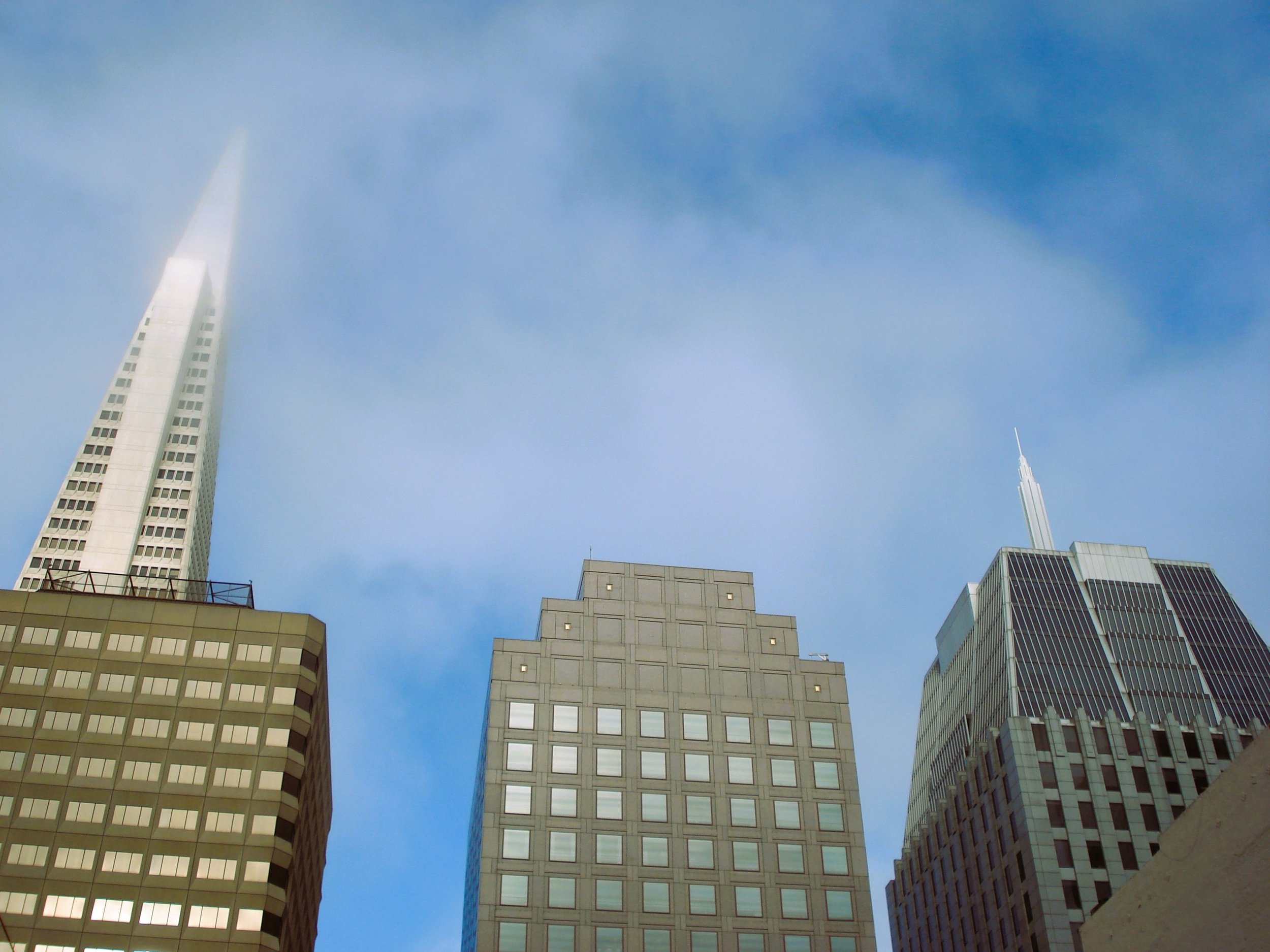 Veduta di grattacieli nella città di New York con cielo blu e nuvole sparse.