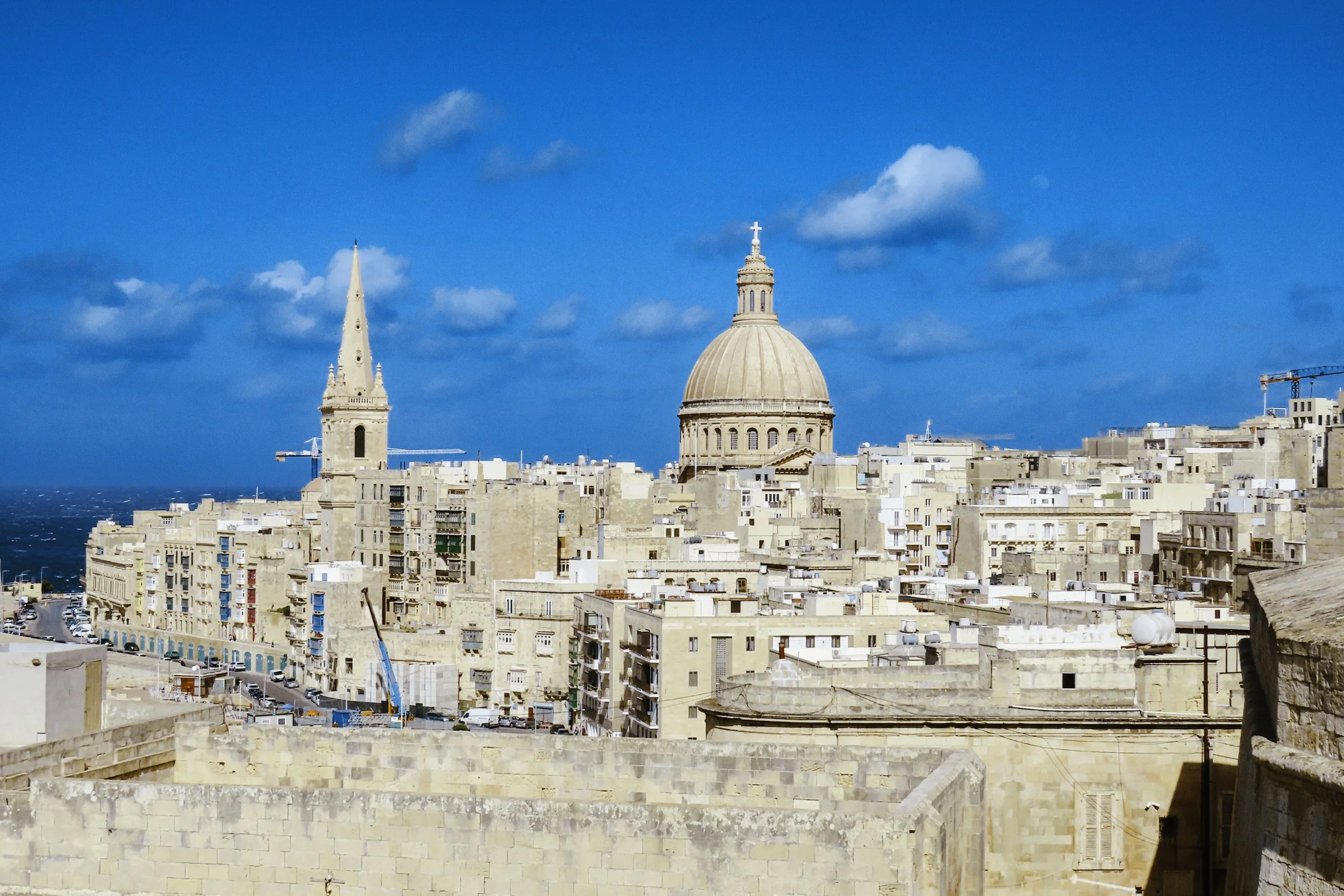 Panorama della città con duomo e campanile sotto un cielo blu