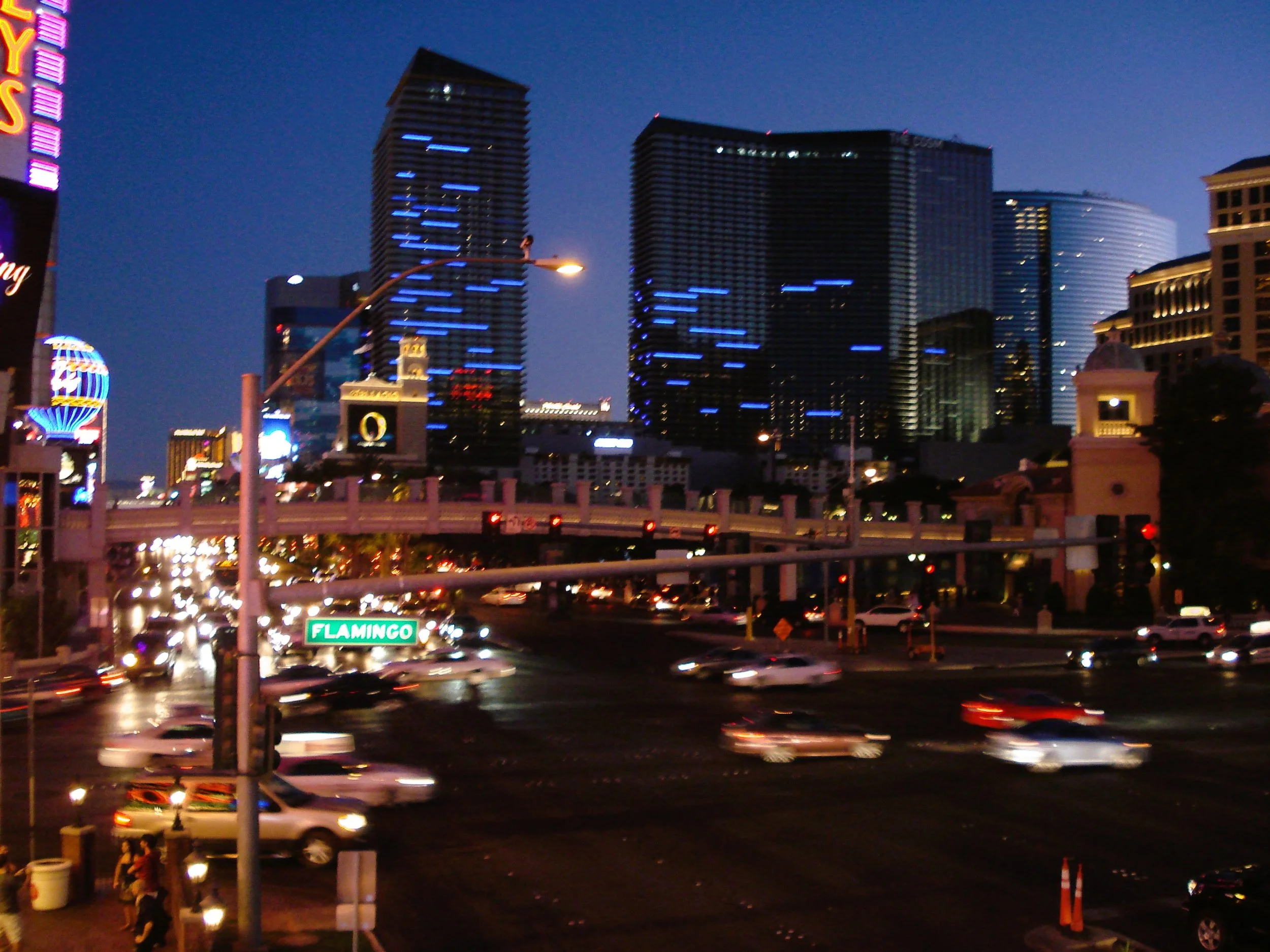 Veduta di una strada trafficata di notte a Las Vegas, con grattacieli illuminati sullo sfondo.