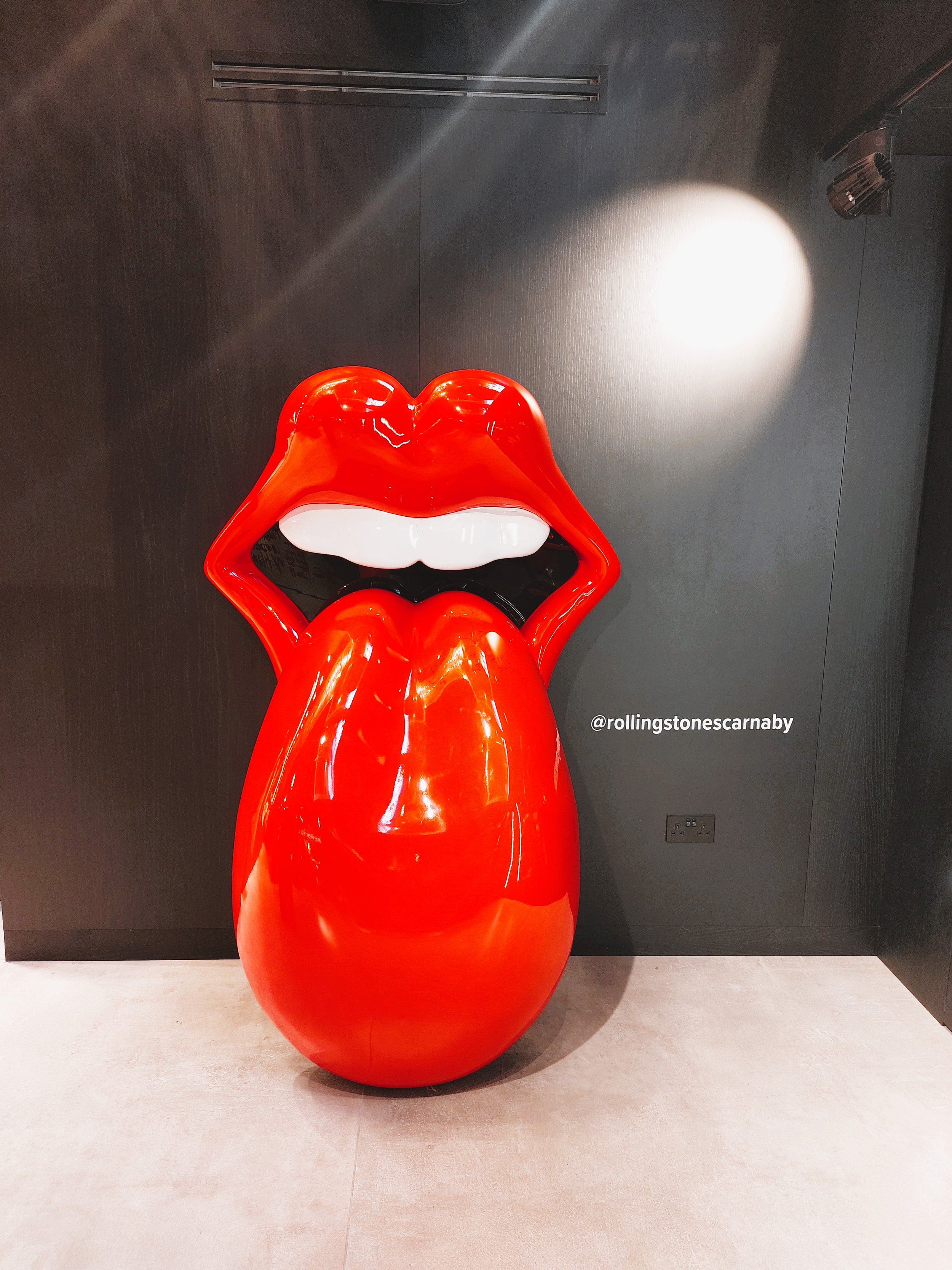 Scultura di un volto stilizzato con labbra rosse e lingua, simbolo iconico dei Rolling Stones
