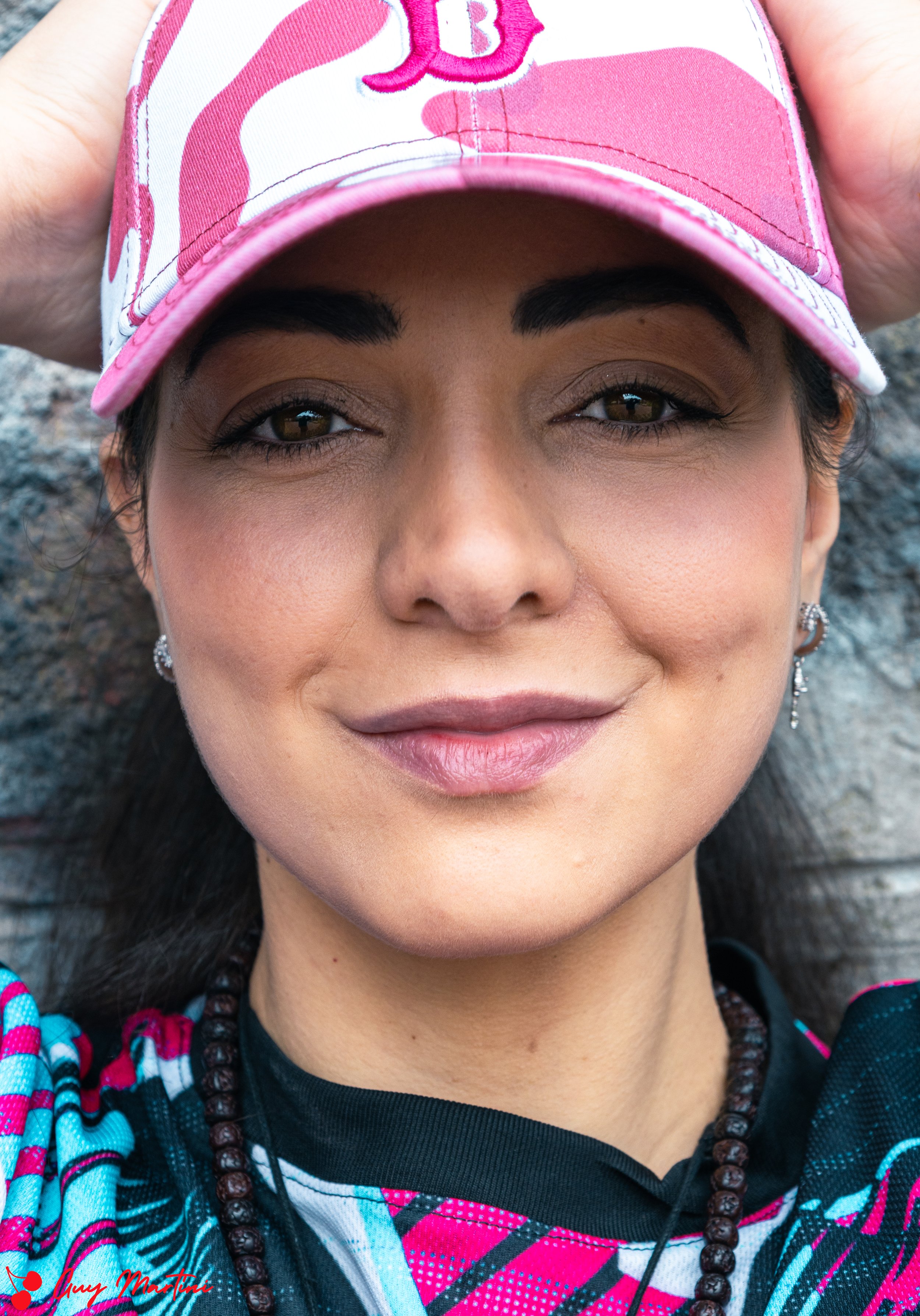 Ragazza con cappellino rosa parlato, sfondo roccia