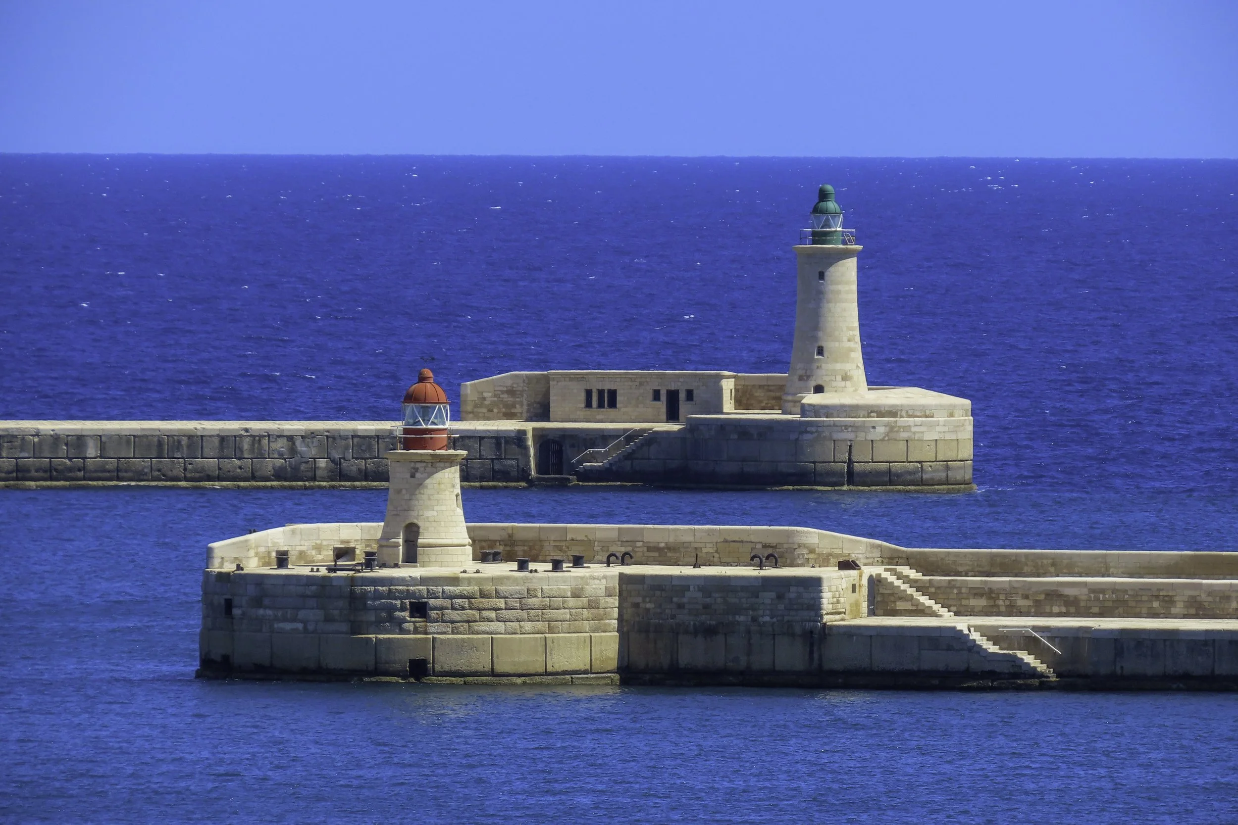 Due fari sulla scogliera del mare in un giorno di sole, con il mare blu e il cielo azzurro
