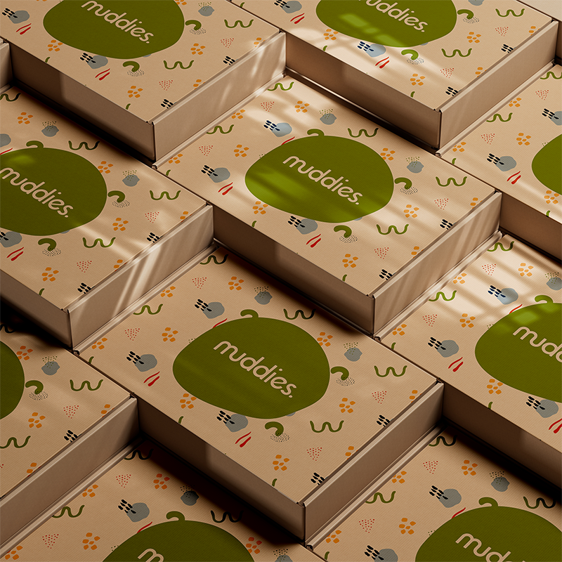 Multiple Nuddies product boxes with a green logo and colorful abstract patterns.