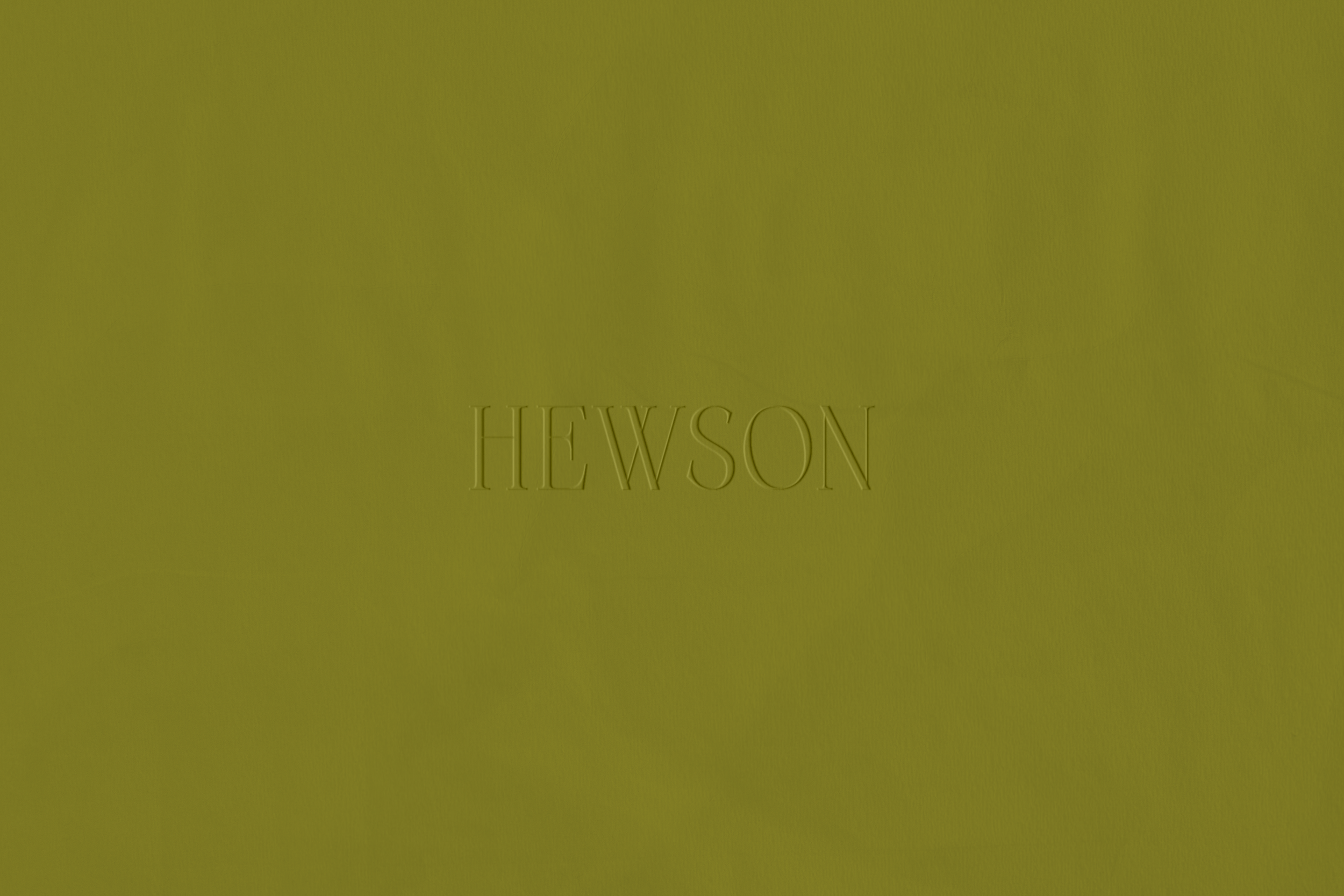 Close-up of a greenish surface with the word 'HEWSon' embossed or engraved at the bottom.