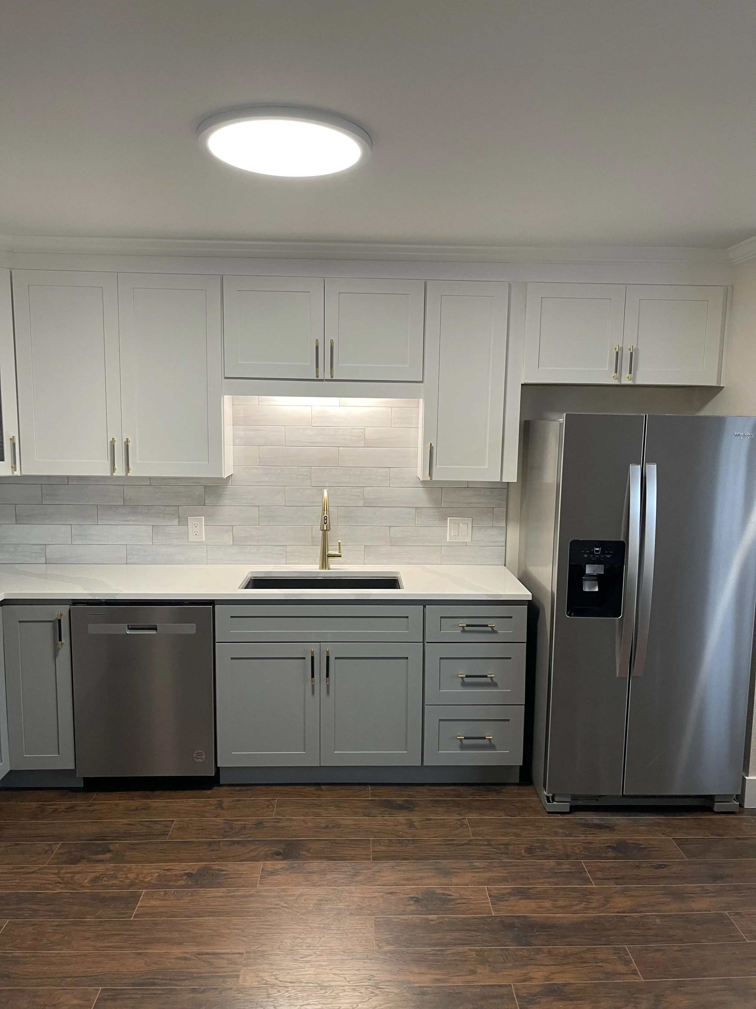 White kitchen cabinets with gold accented hardware and sink