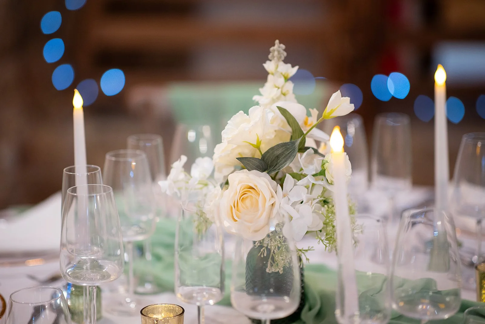 Tiffany mini floral arrangement styled on a wedding top table with candles.