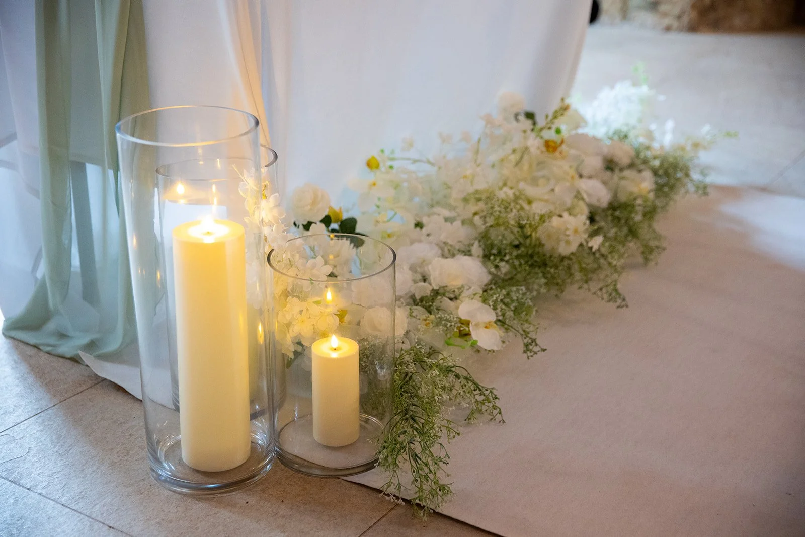 Tiffany floral package aisle arrangement with glass cylinder candles and white rose hydrangea faux flowers available from Rosewood & Pearl.