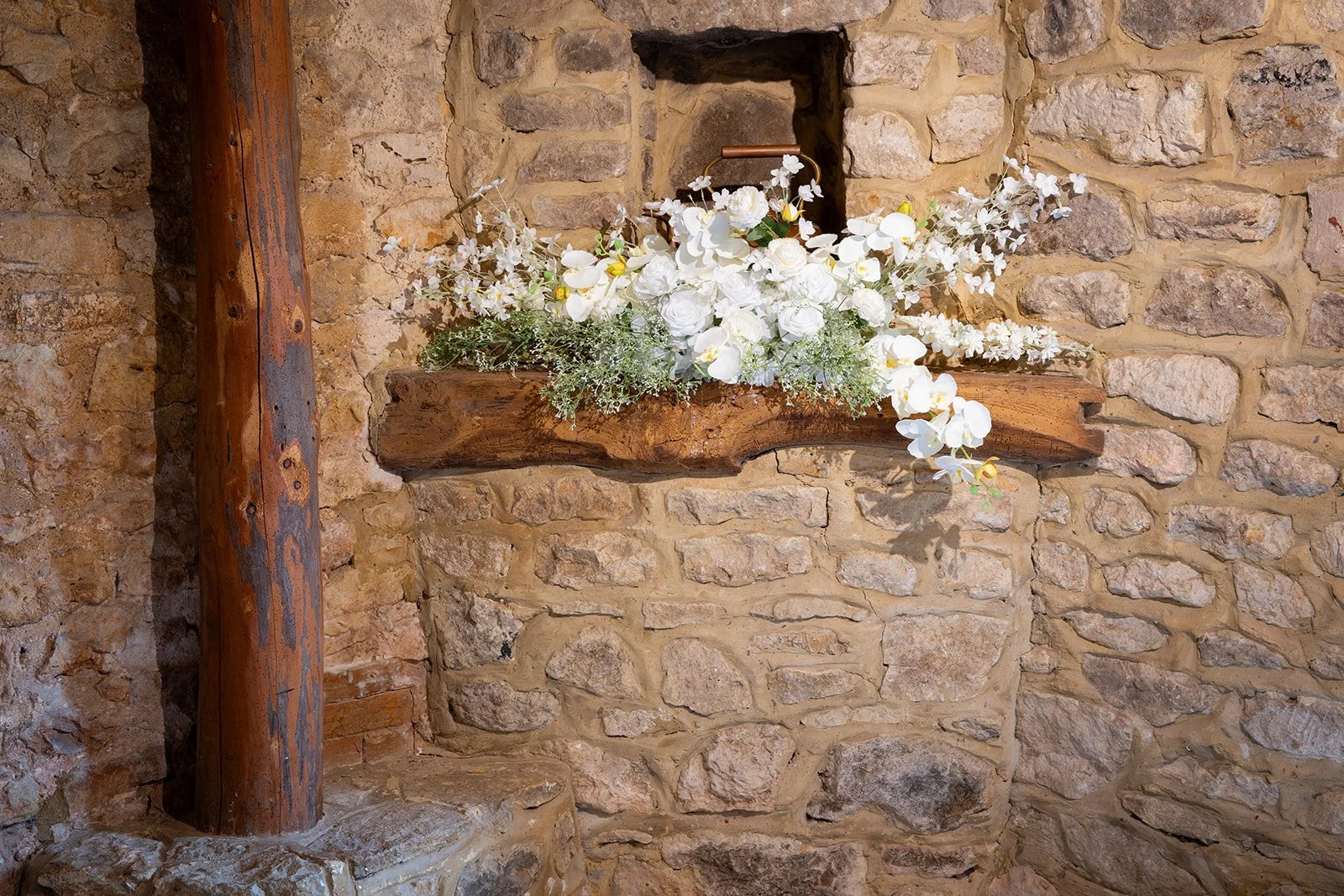 Tiffany collection faux floral arrangement with white roses hydrangeas and greenery styled on rustic stone mantel available from Rosewood & Pearl