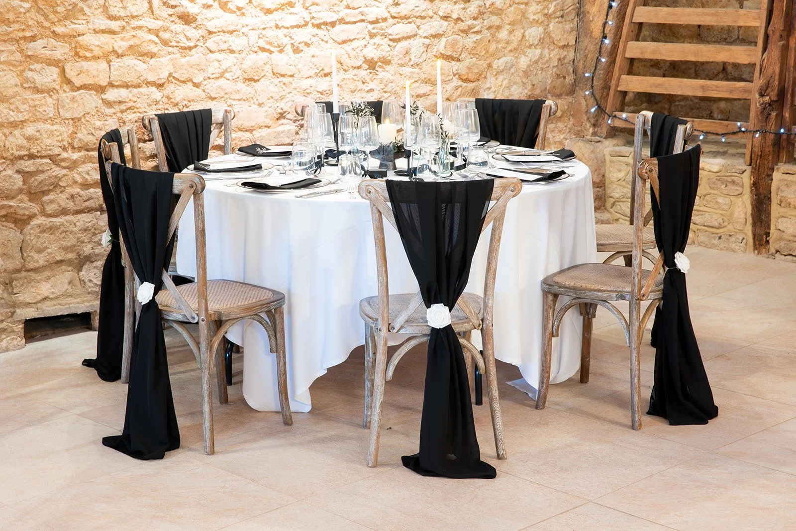 Black chair drape with white rose embellishment by Rosewood & Pearl