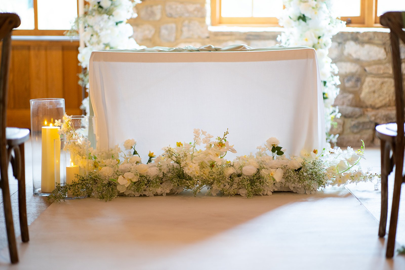 Long Tiffany floral arrangement used for wedding aisle styling with candles