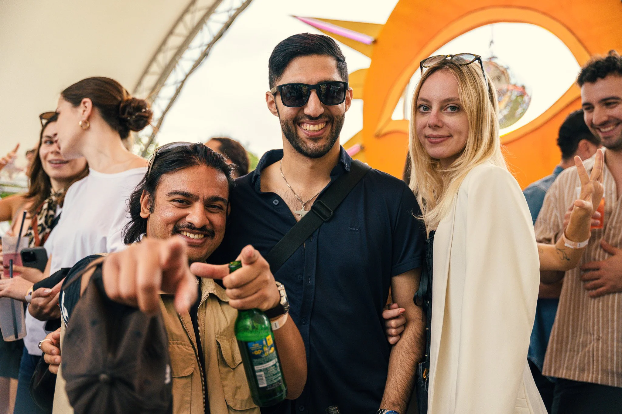 Group of friends at a festival, smiling and posing for the camera, with orange decorations in the background.