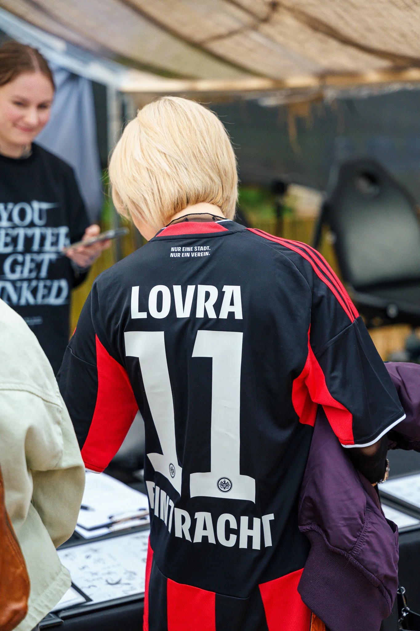 Back of a person wearing a black and red football jersey with the name 'LOVRA' and number '11'.