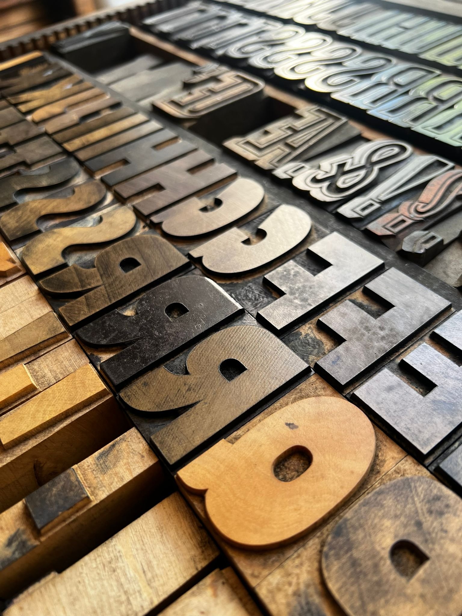 Close-up of vintage metal letter stamps on a wooden surface.