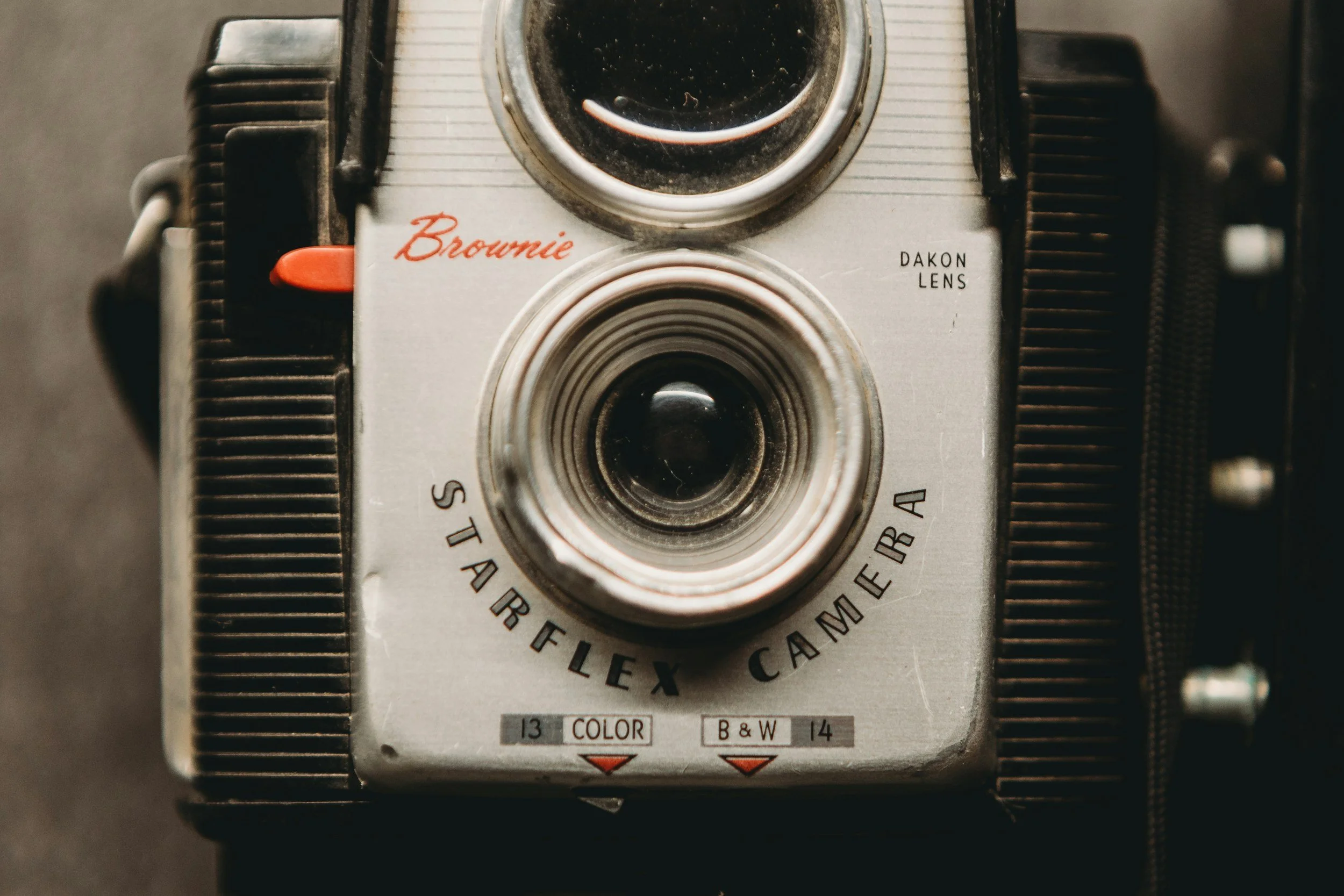 A vintage Starflex camera with a silver body, black textured sides, and various labels including 'Brownie' and 'Starflex Camera' on the front.