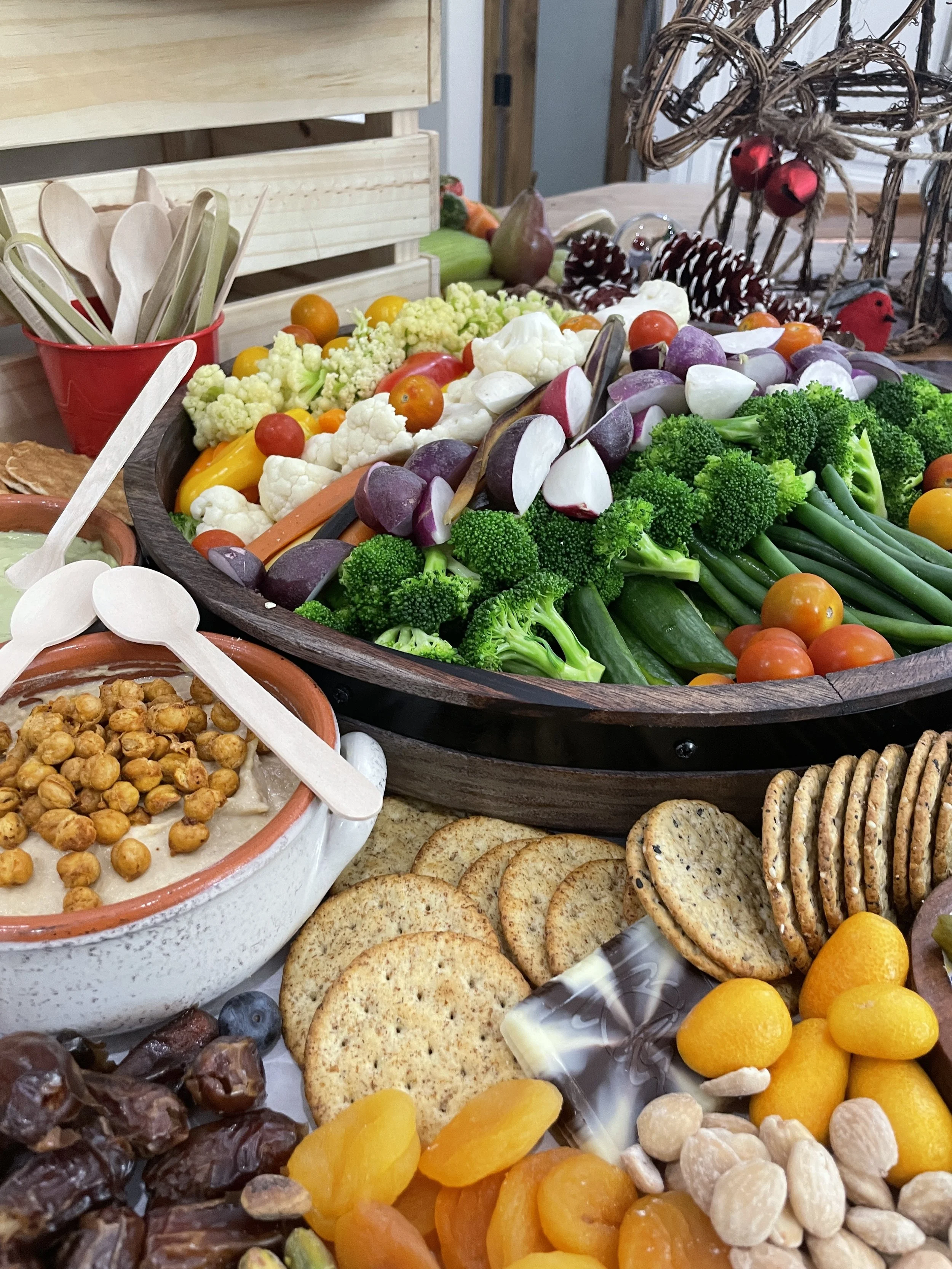 Assorted fresh vegetables, crackers, nuts, and candies on a table for a holiday celebration