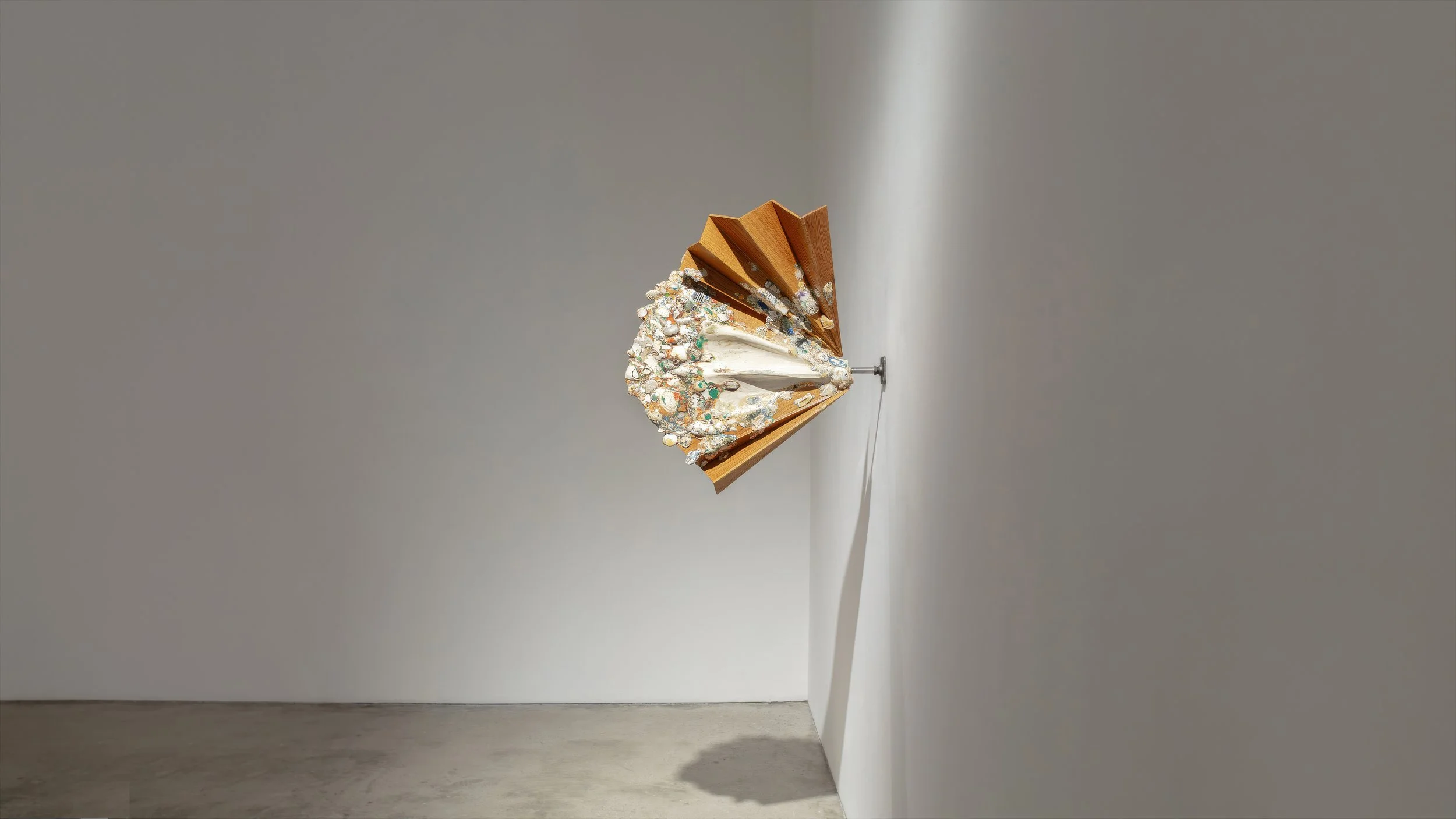 Yasue Maetake Mare Fecunditatis room view: human-scale orange-brown form on tripod base left, long horizontal bar with dangling multicolored forms center, row of small pieces on shelf right in white gallery