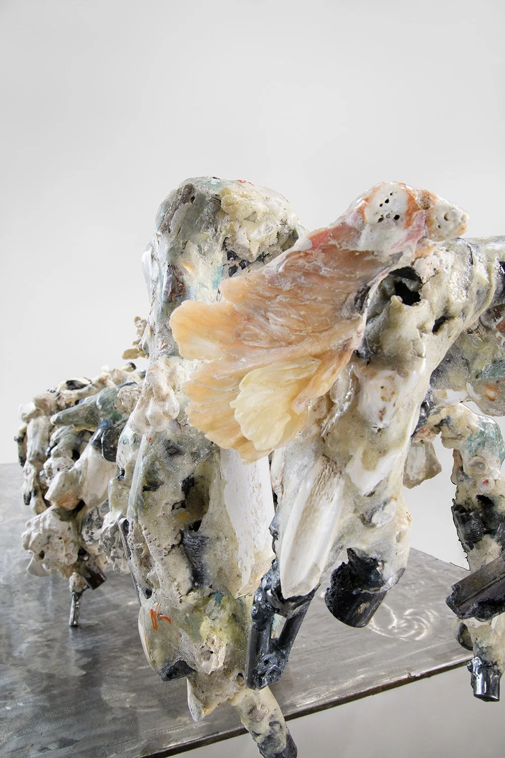 Yasue Maetake's sculpture Mare Fecunditatis – resurrection, 2025. Close-up detail of the dynamic multi-limbed hybrid section showing chaotic, creature-like organic forms in white and gray tones with metallic accents and extended structural elements.