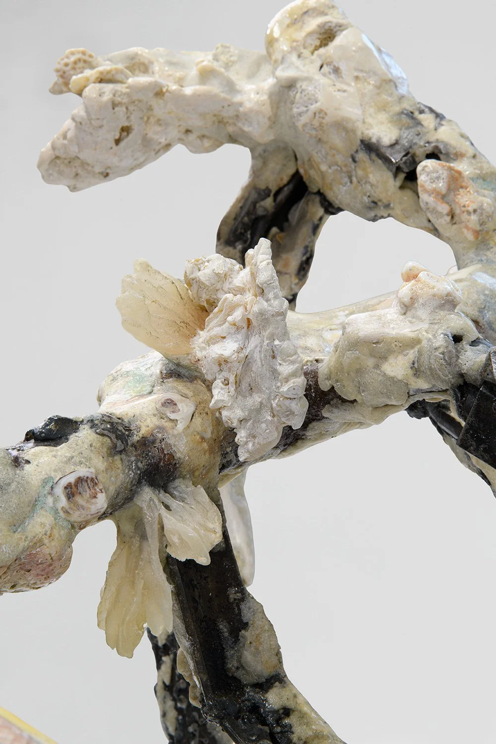 Yasue Maetake's sculpture made of various materials resembling a dragon or mythical creature, with textured, layered surfaces and a mix of colors including cream, white, black, and brown.