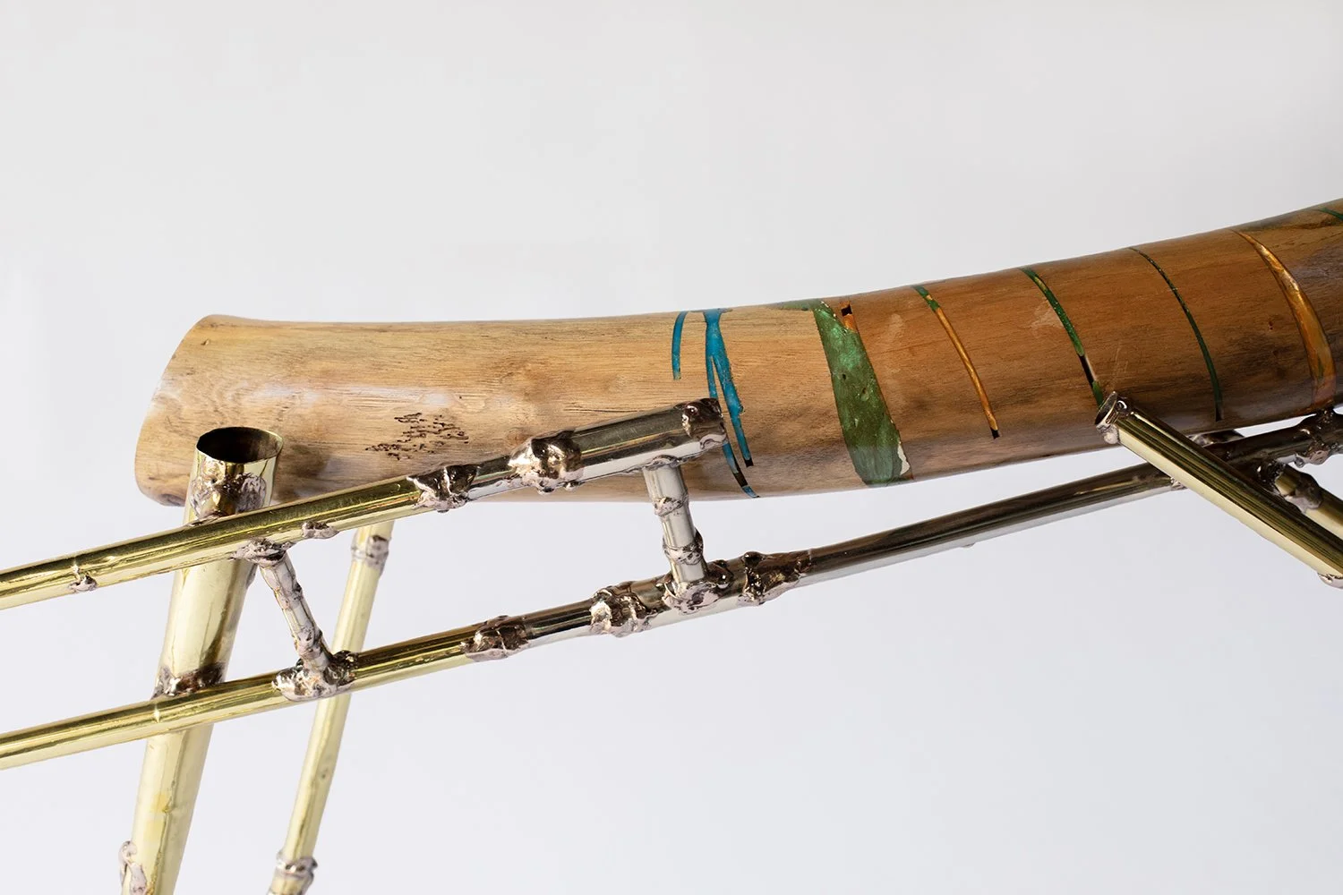 Close-up of a saxophone with a wooden mouthpiece and metallic body against a plain background.