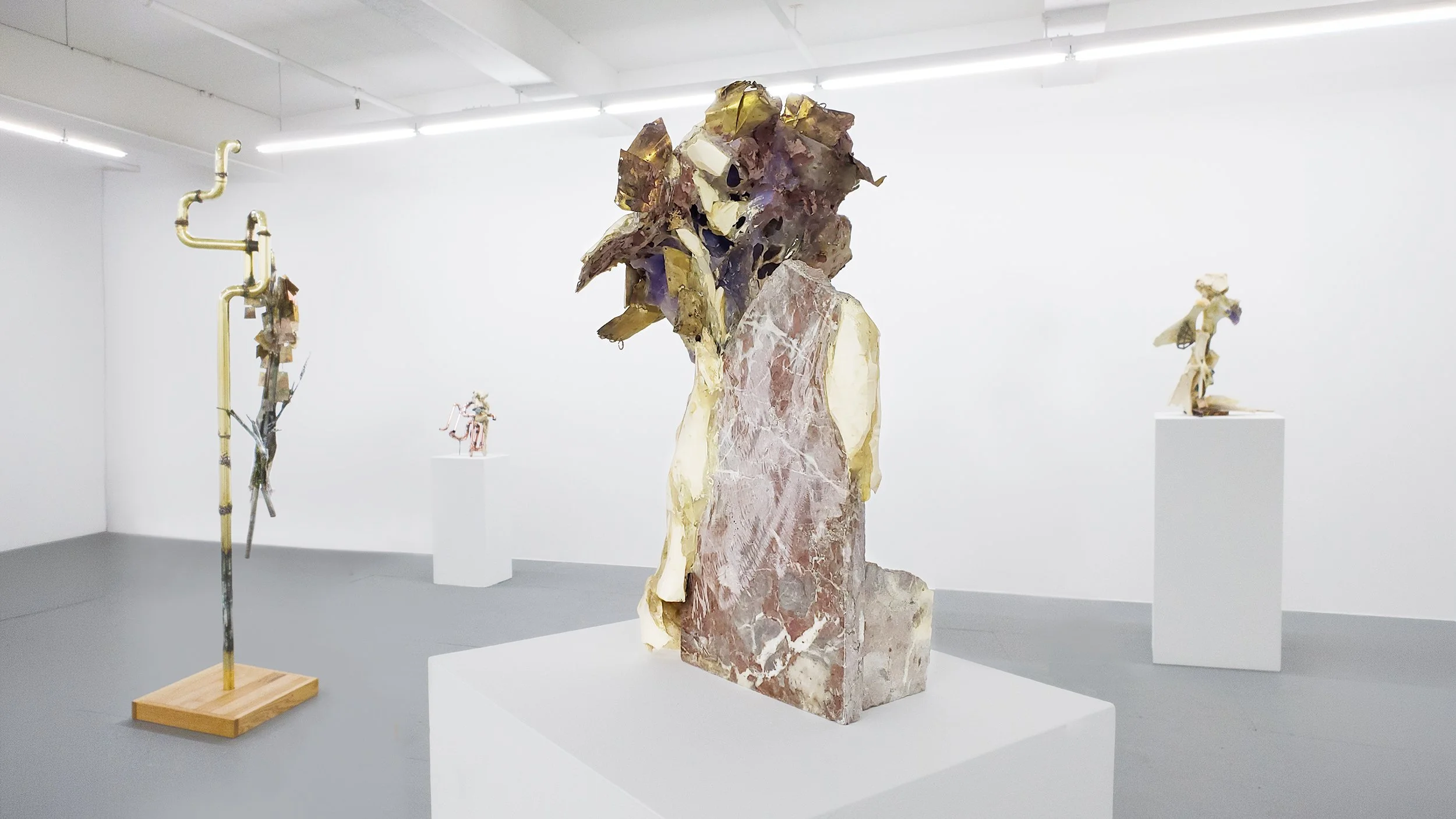 Yasue Maetake Transmutation gallery installation: non-representational sculpture with a granite base and upper section of metal fragments, other bone and metal sculptures visible in the background