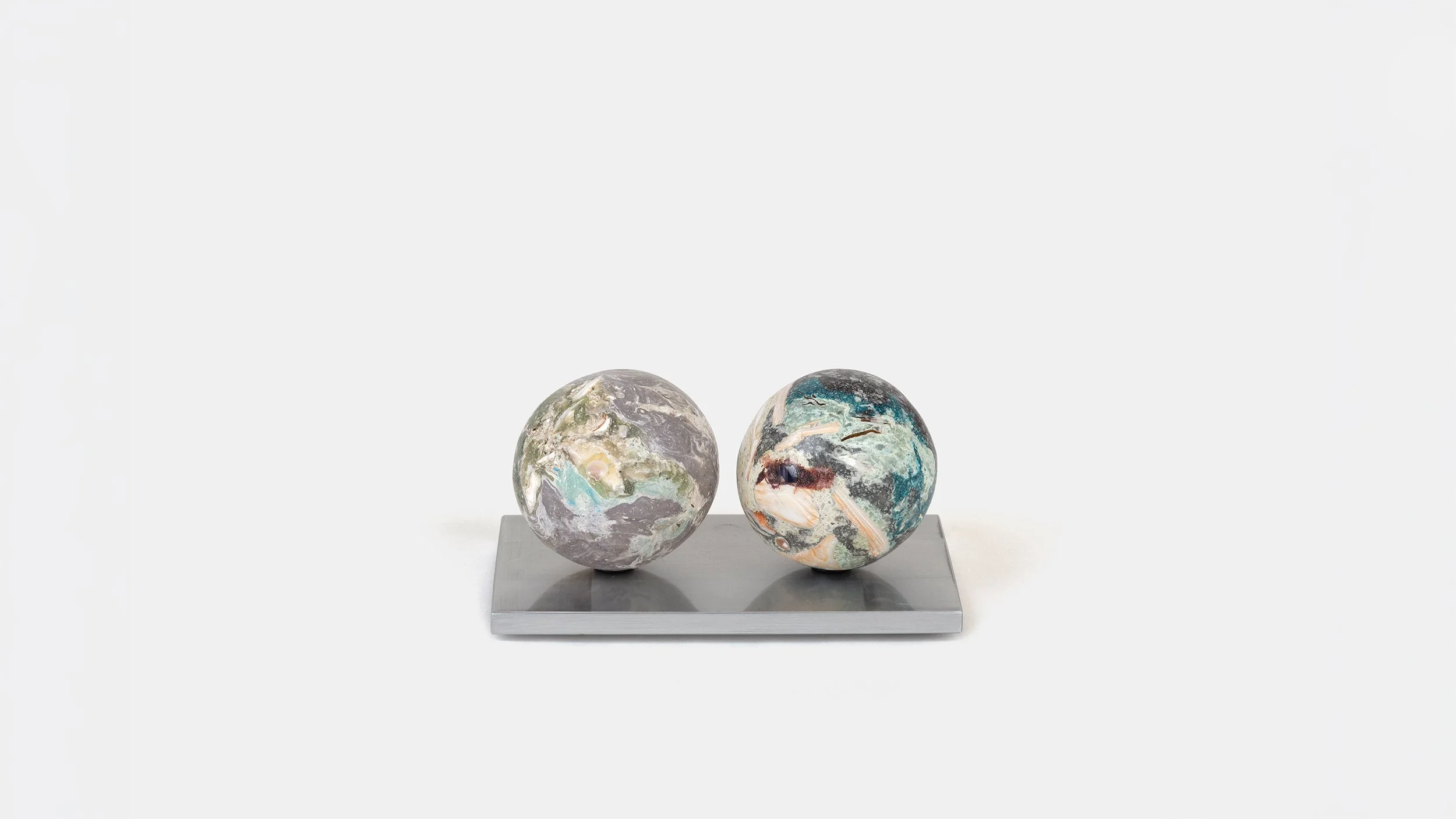 Yasue Maetake Orb Materia—Carved Algos detail: two multicolored carved spheres side by side on a single rectangular aluminum base against white background