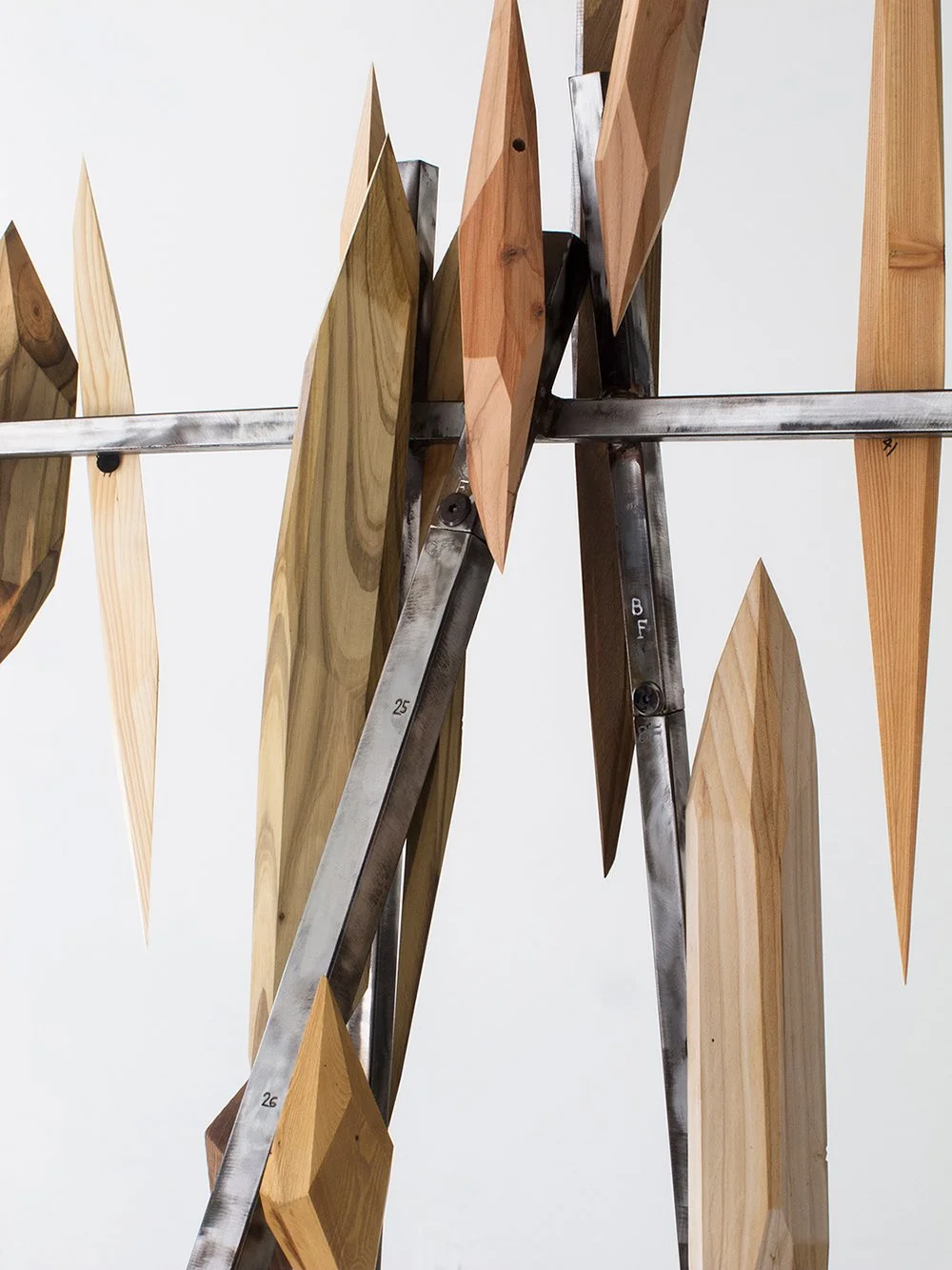 Close-up of Arbor Armor (2015-2026) with various wooden geometric shapes arranged on a steel frame.