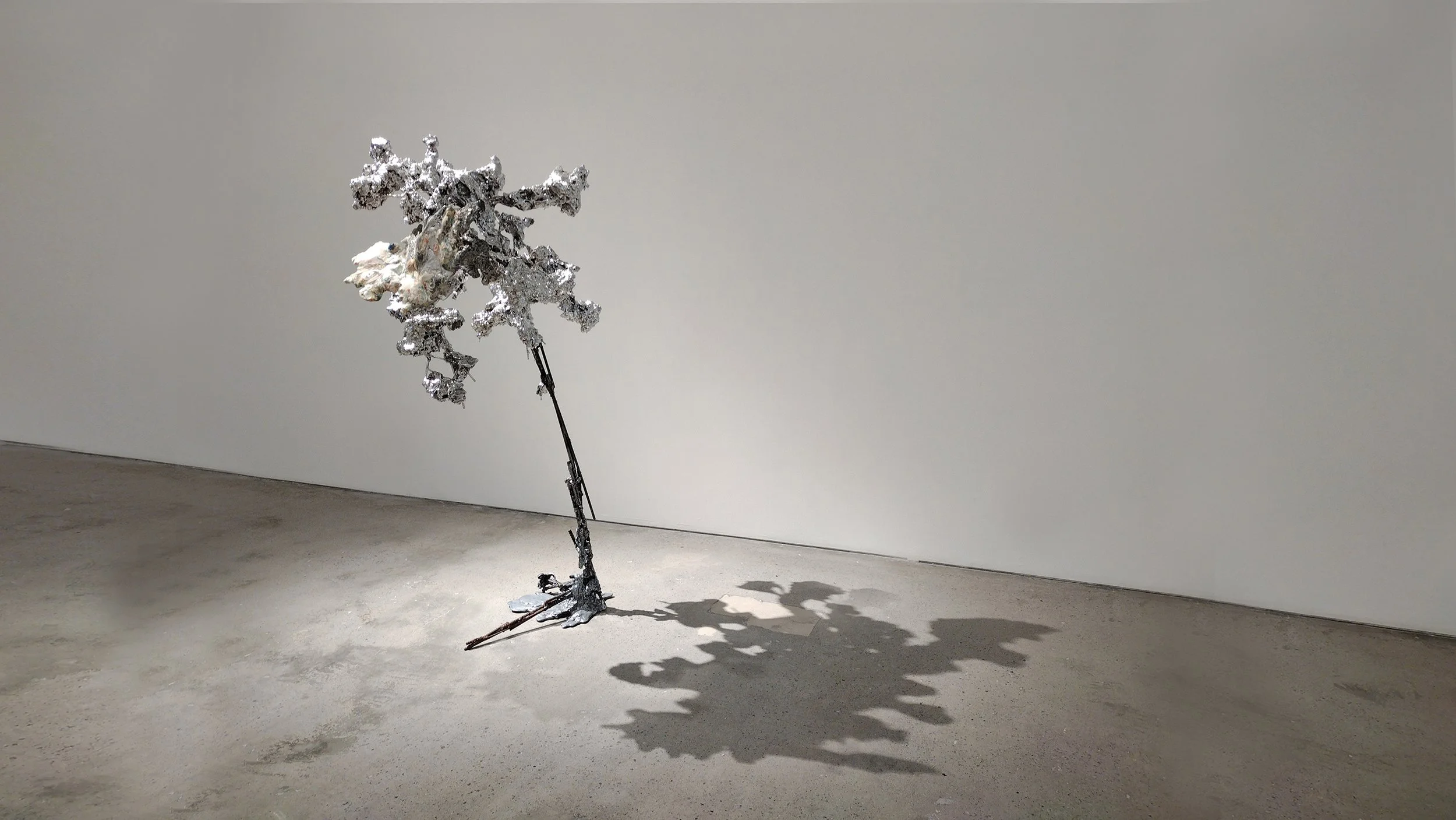 Yasue Maetake Mare Fecunditatis medium-distance shot: tall silvery crystalline tree-like structure with branched textured forms on gray floor against white background