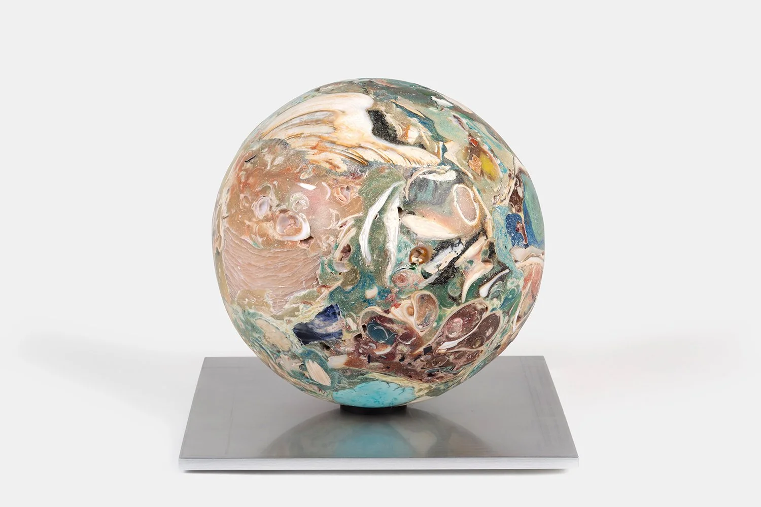 Yasue Maetake Orb Materia—Inlet Swallowtail, 2026. Large spherical form with layered pinkish-beige, turquoise, green, and white mineral surfaces containing shell fragments, resting on a square aluminum base.