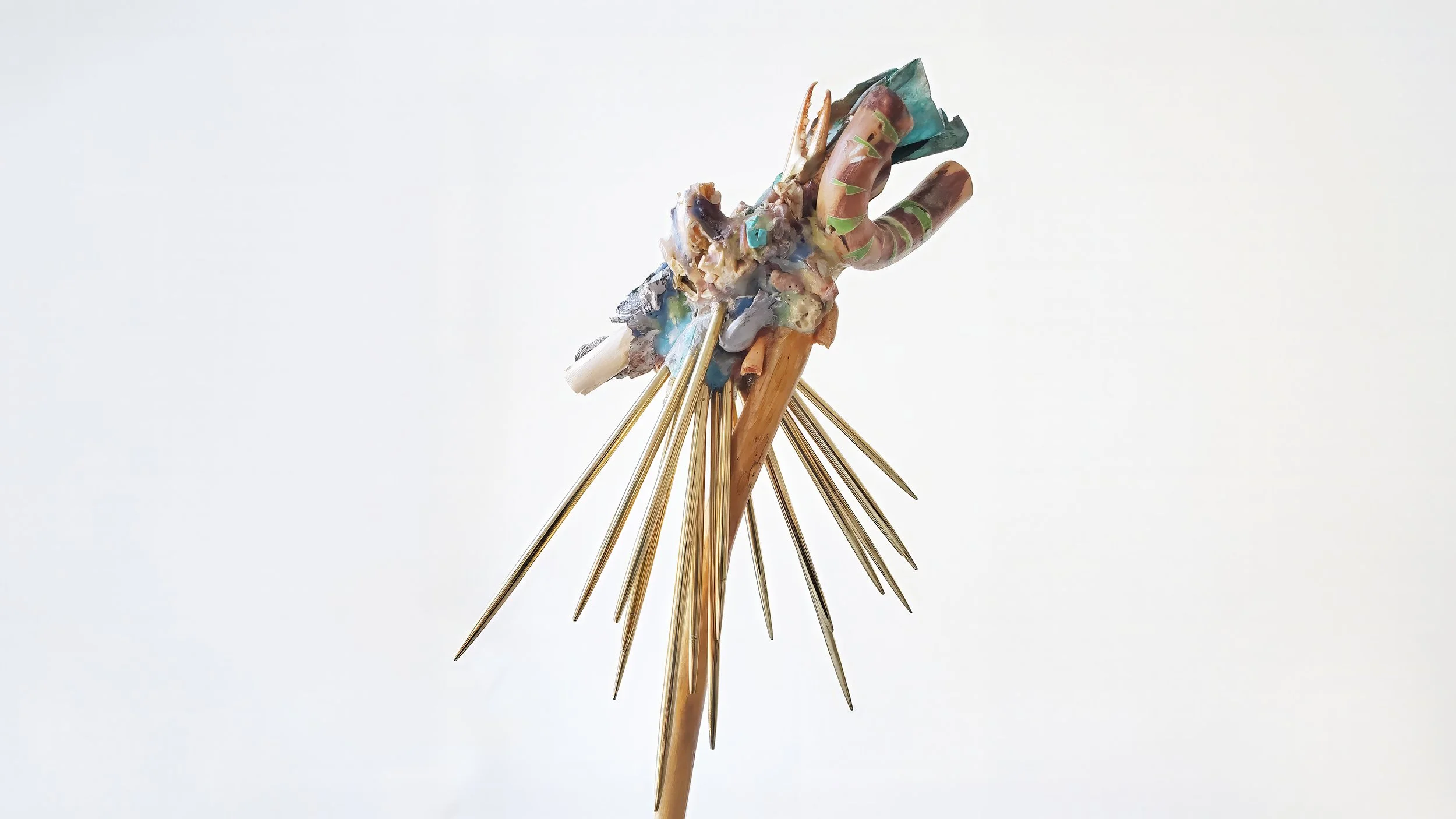 Yasue Maetake Three-Legged Idols detail: close-up of organic multicolored head-like form with radiating long gold spikes against white background