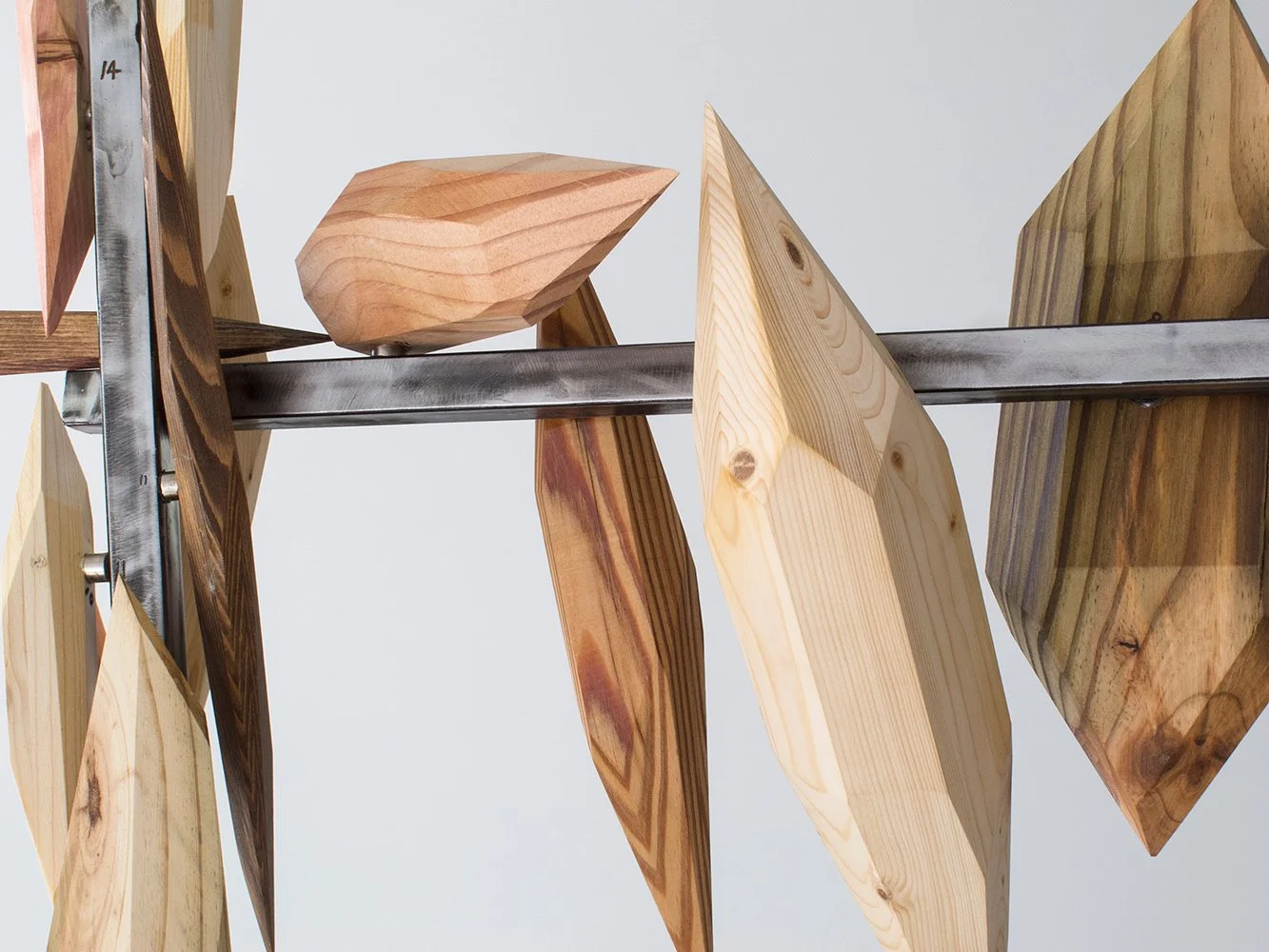 Wooden geometric sculptures mounted on a metal rod