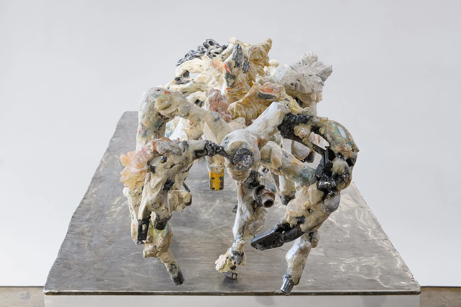 Yasue Maetake's sculpture Mare Fecunditatis – resurrection, 2025. Elevated angled view of the multi-limbed hybrid sculpture showing chaotic, creature-like organic forms in white and gray tones with black metallic accents and textured surfaces, displa