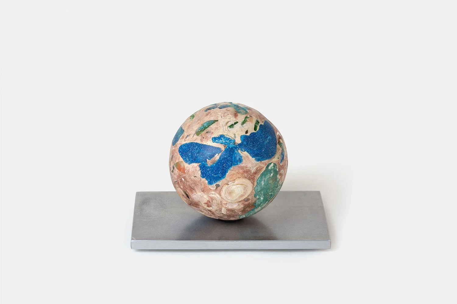 Yasue Maetake Orb Materia—Blue First Aid, 2026. Spherical sculpture with prominent blue mineral patches on a pinkish surface, resting on a rectangular aluminum base.