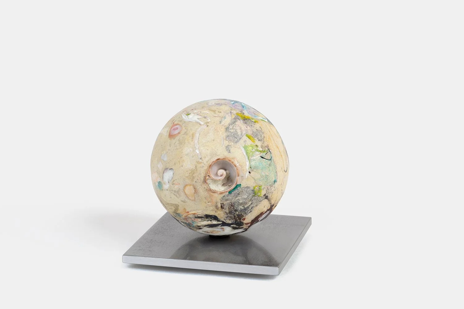Yasue Maetake Orb Materia—Silken, 2026. Spherical form with soft beige mineral surface and a central spiral shell fragment, resting on a square aluminum base.