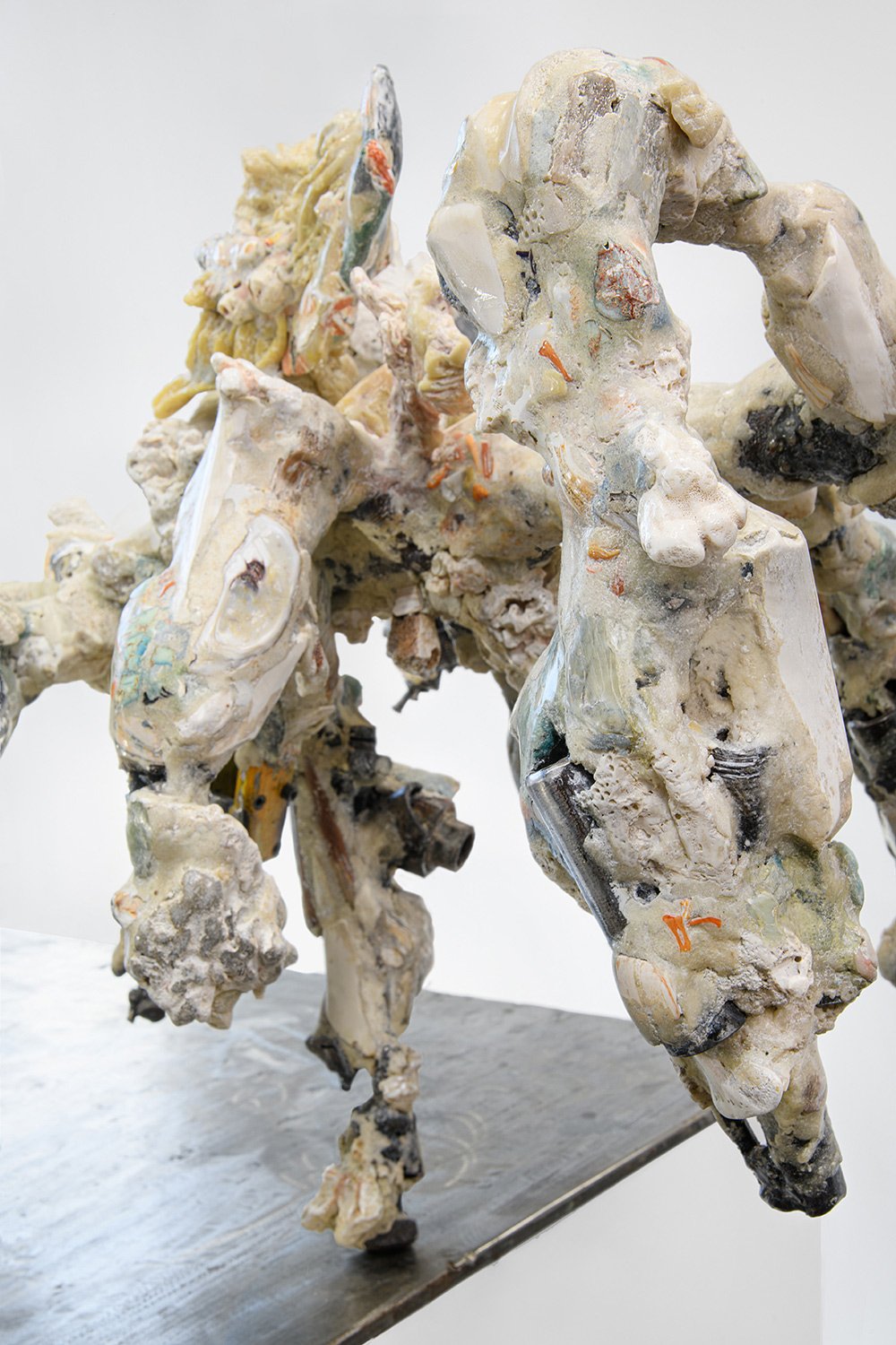 Yasue Maetake's sculpture Mare Fecunditatis – resurrection, 2025. Close-up angled view of the multi-limbed hybrid sculpture showing chaotic, creature-like organic forms in white and gray tones with rough textured surfaces and prominent dark metallic 