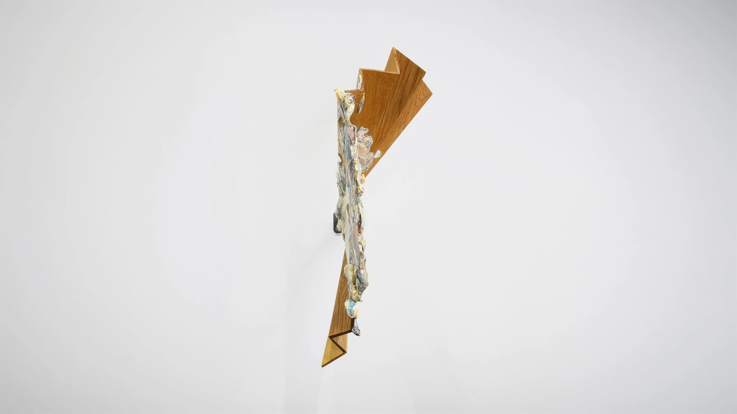 Yasue Maetake Mare Fecunditatis detail: frontal view of light oak pleated wooden fan wall piece with dense multicolored organic form of shells, stones, and metallic elements against white background