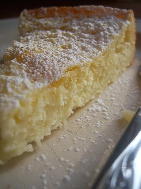 Lemony Cream Butter Cake. A slice of cheesecake dusted with powdered sugar on a serving plate. In St. Augustine, Florida.