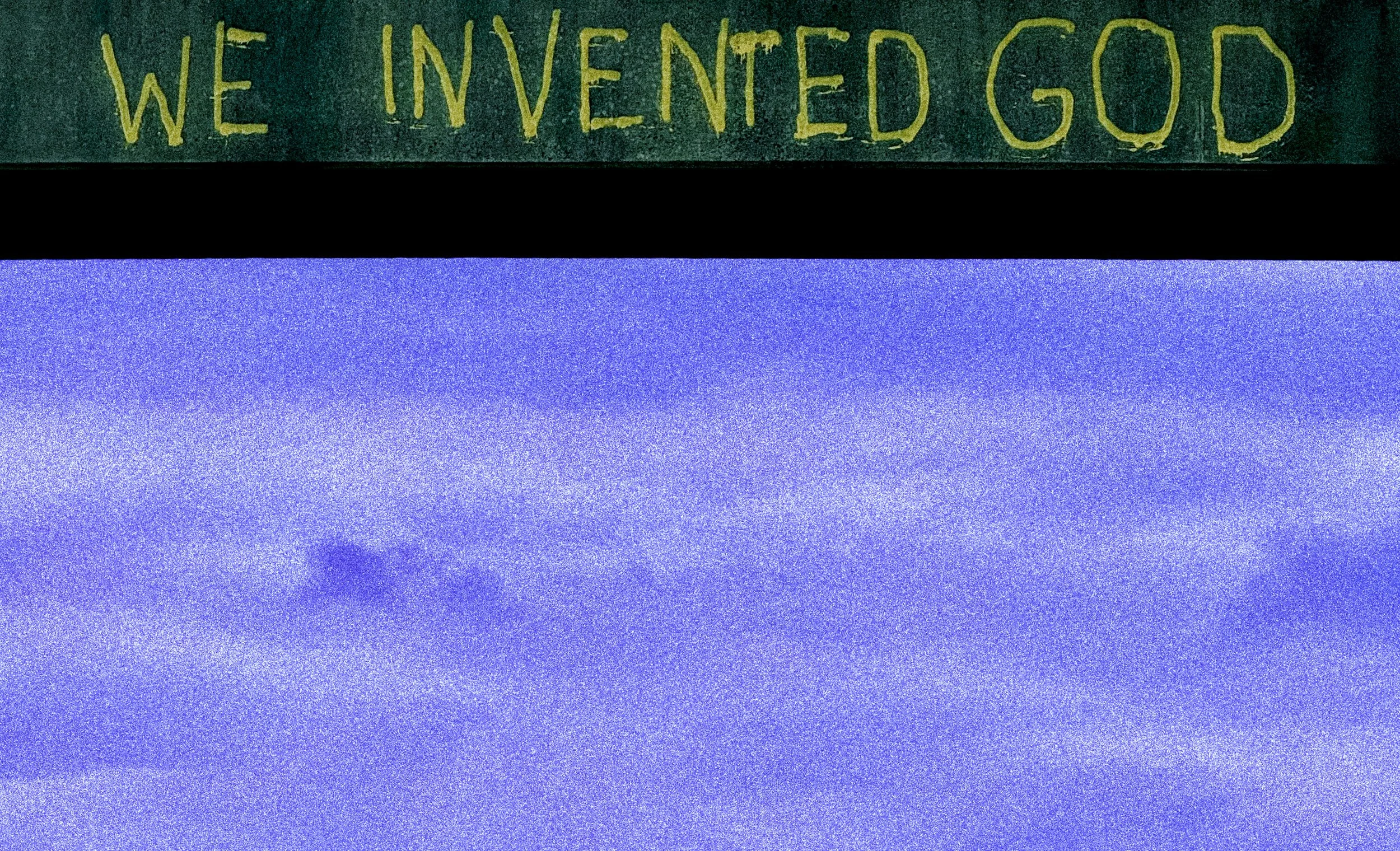 Part of a wall with a sign that says 'WE INVENTED GOD' near the top. The image quality is grainy and shows a purple sky with some clouds.