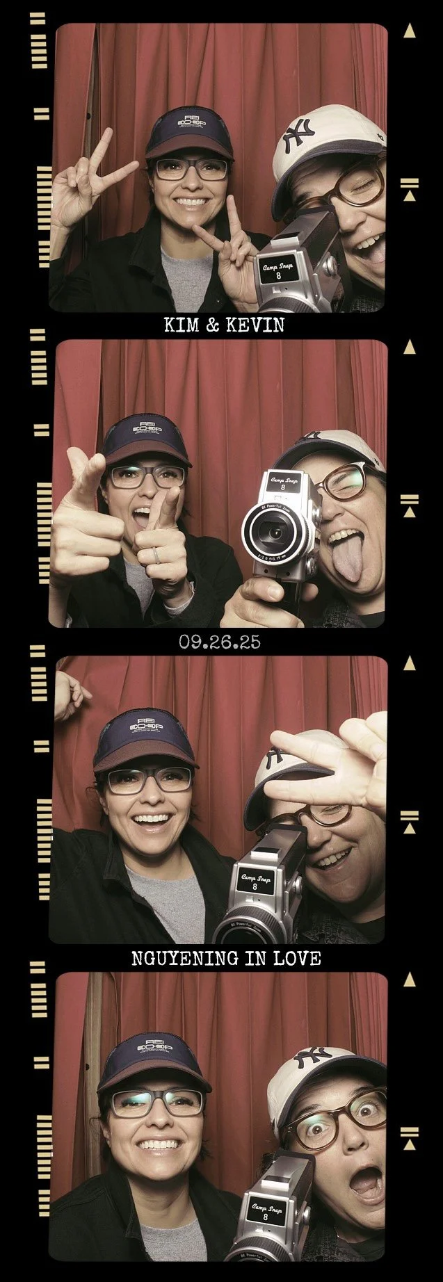 Two women taking playful photos in a photo booth with a red curtain background. They are smiling, making peace signs, and pretending to shoot with a vintage camera, with one sticking out her tongue. Their outfits include caps and glasses. The photo strip is labeled with the date 09.26.25 and text "KIM & KEVIN" and "NGUYEN IN LOVE."