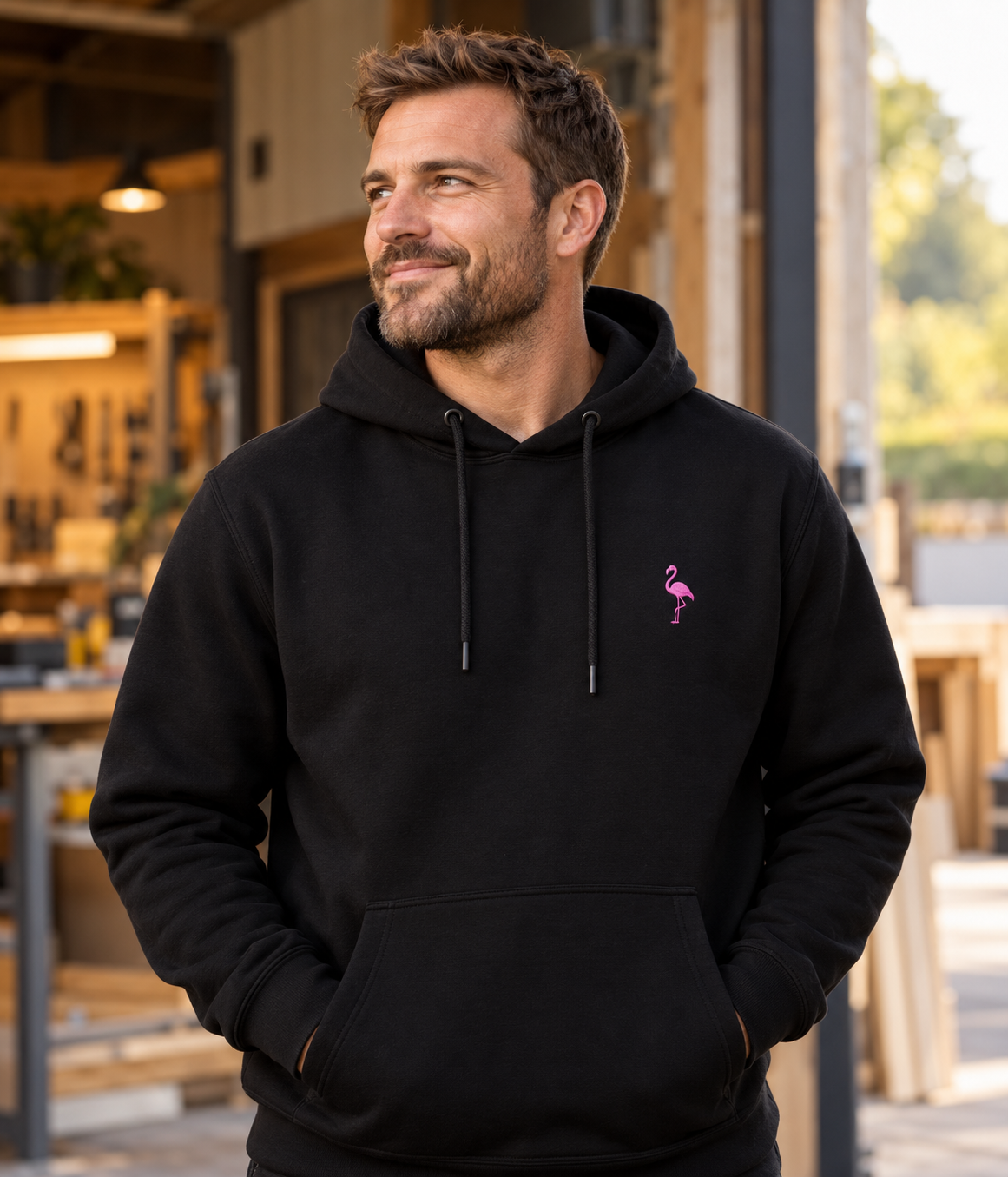 Business owner wearing a black hoodie with a pink flamingo emblem