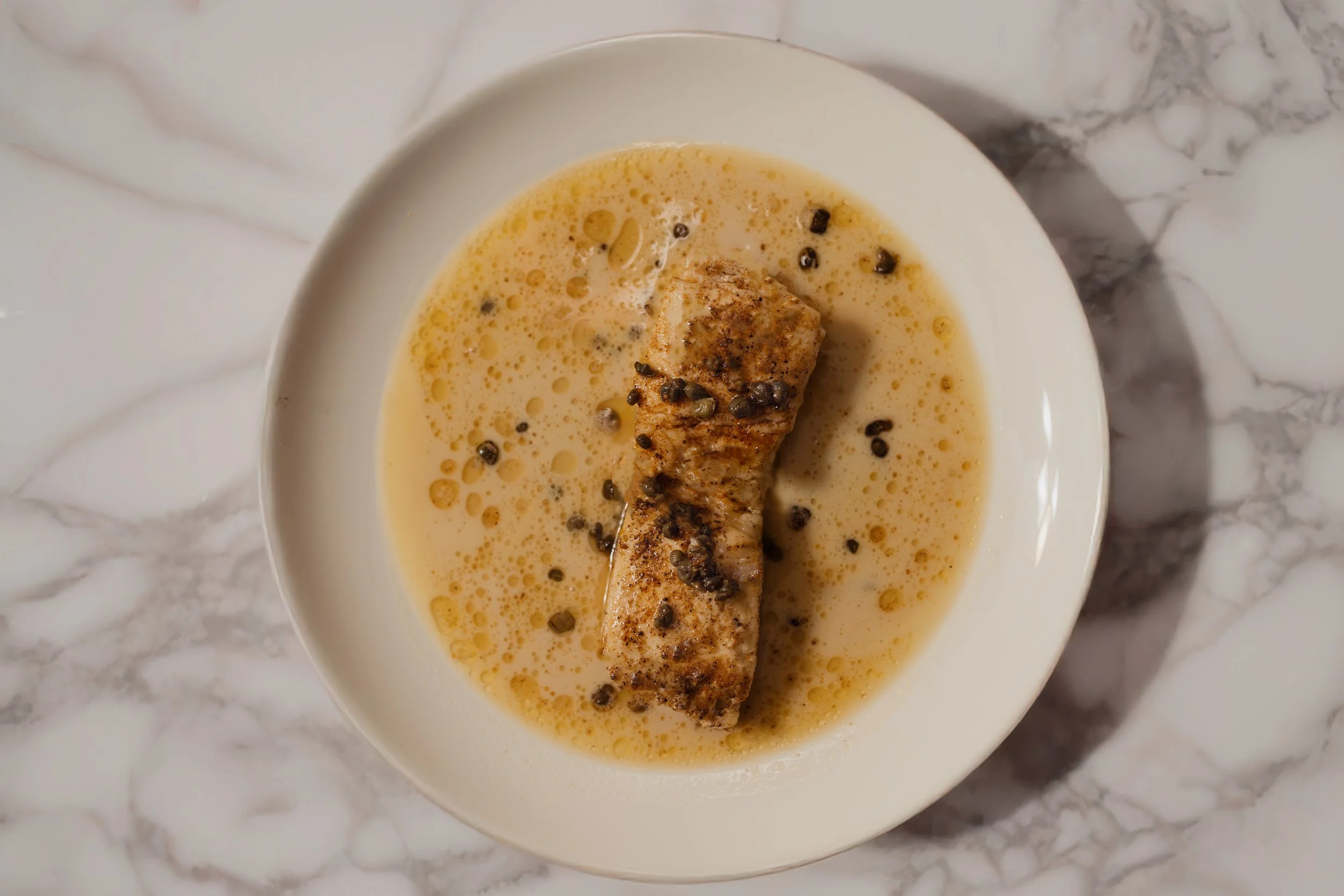 Pan Fried Halibut Over A Veloute Sauce with Capers