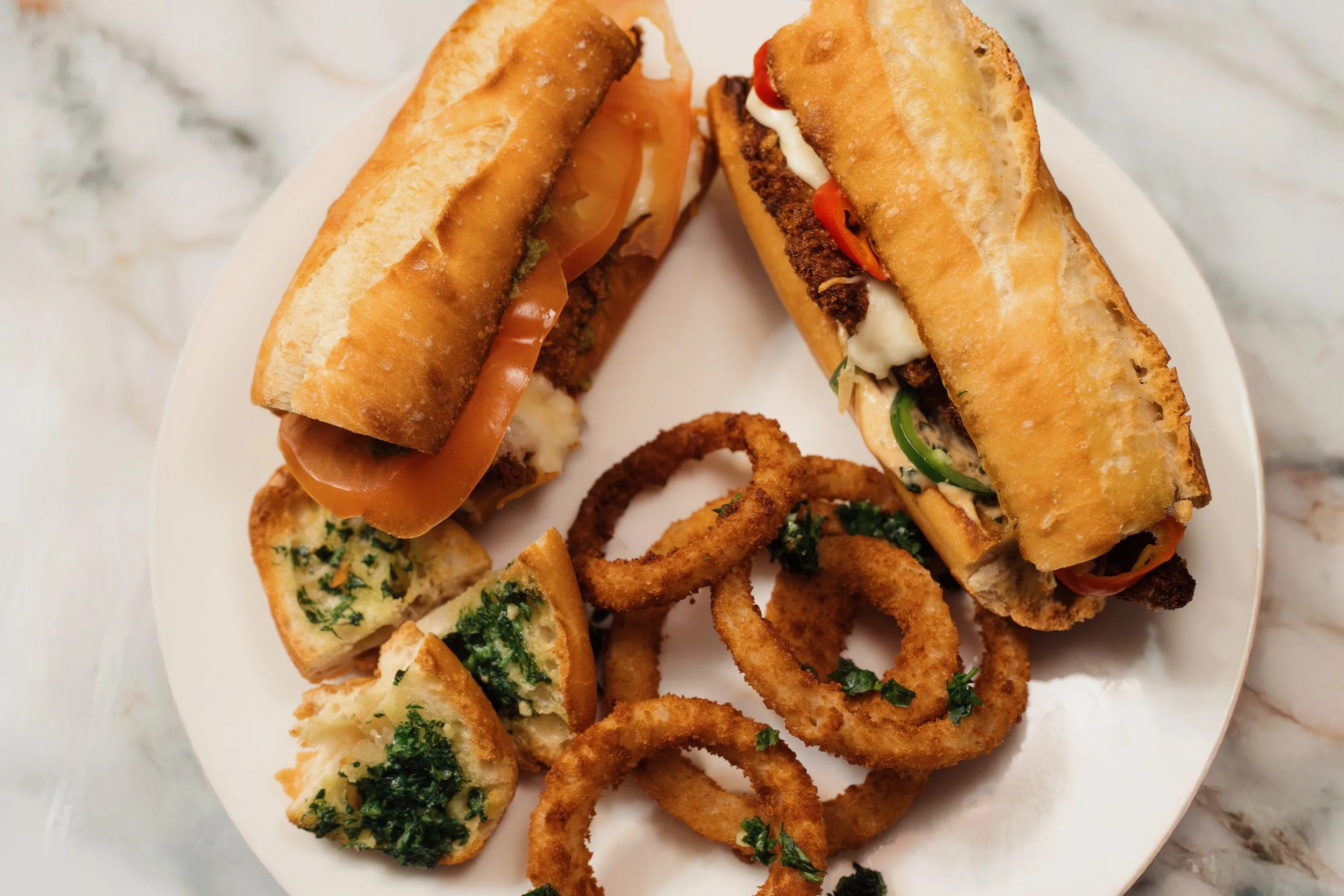 Spicy Chicken Cutlet Sandwiches with Onion Rings and Roasted Garlic Bread
